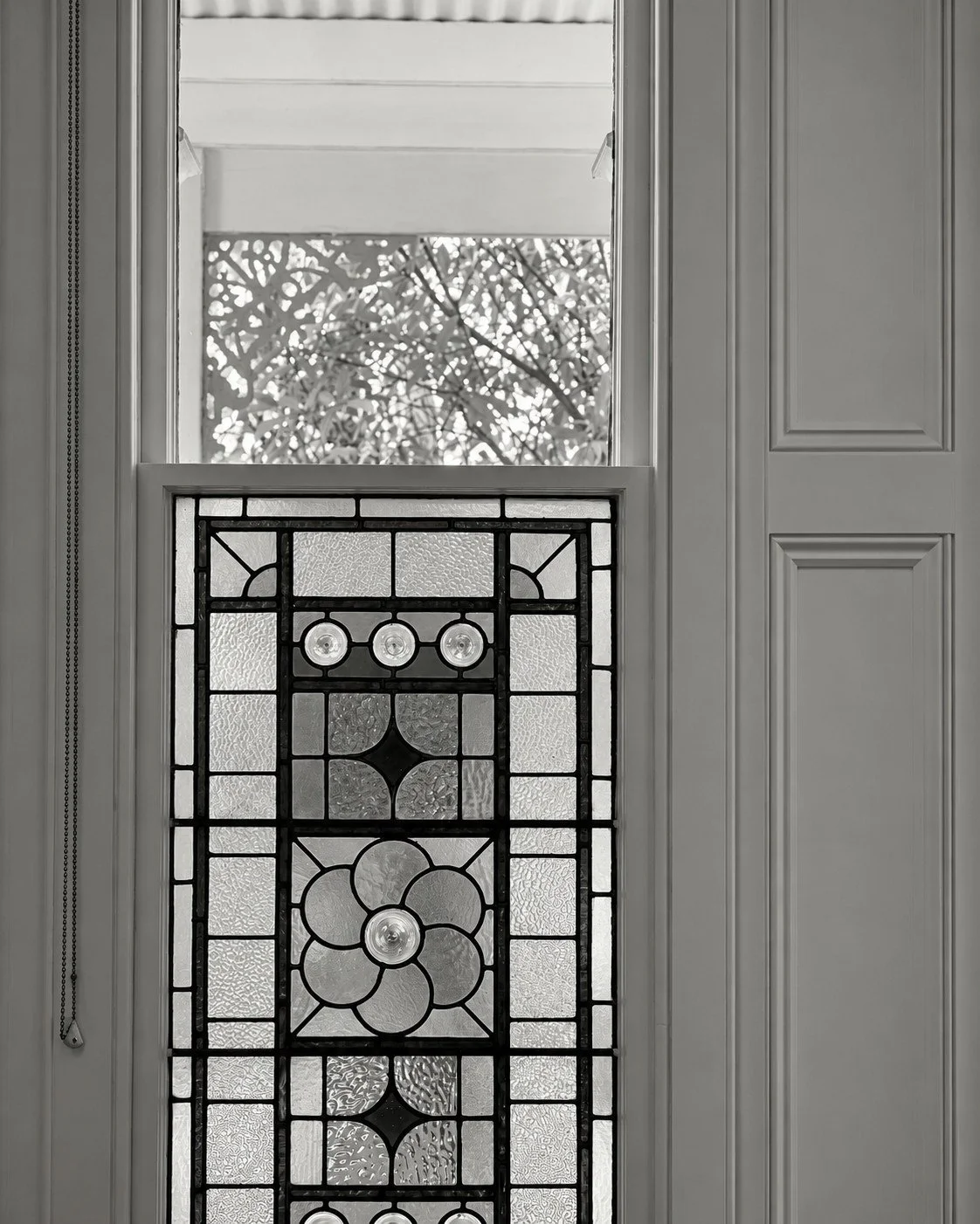 Craigneal original leadlight window with patterned glazing and timber shutters.