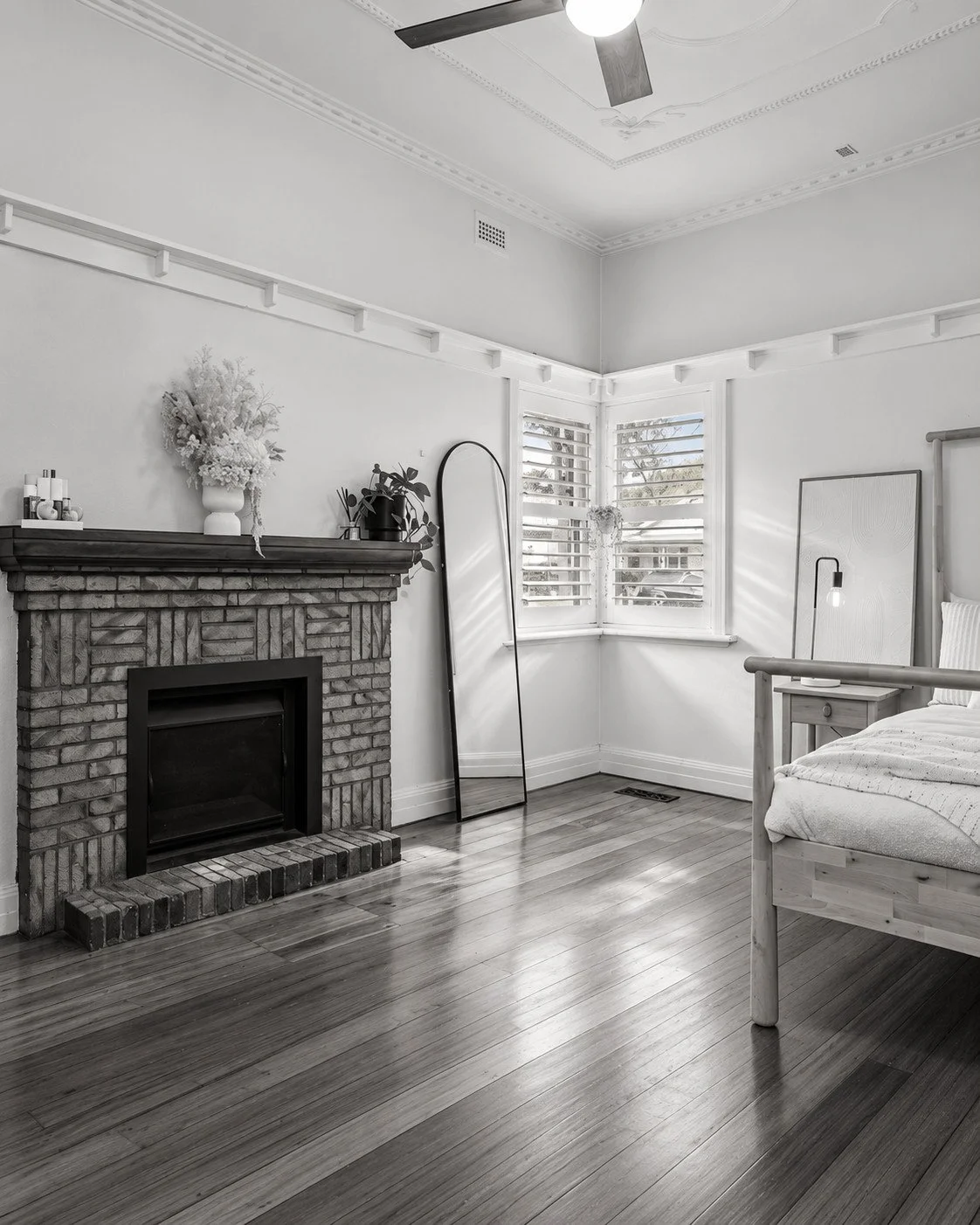 Botanica original living room with a brick fireplace, decorative cornice and timber floor.