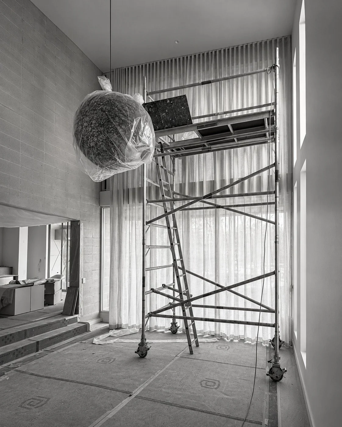 Lorde House construction progress with a sculptural pendant suspended above an unfinished interior.