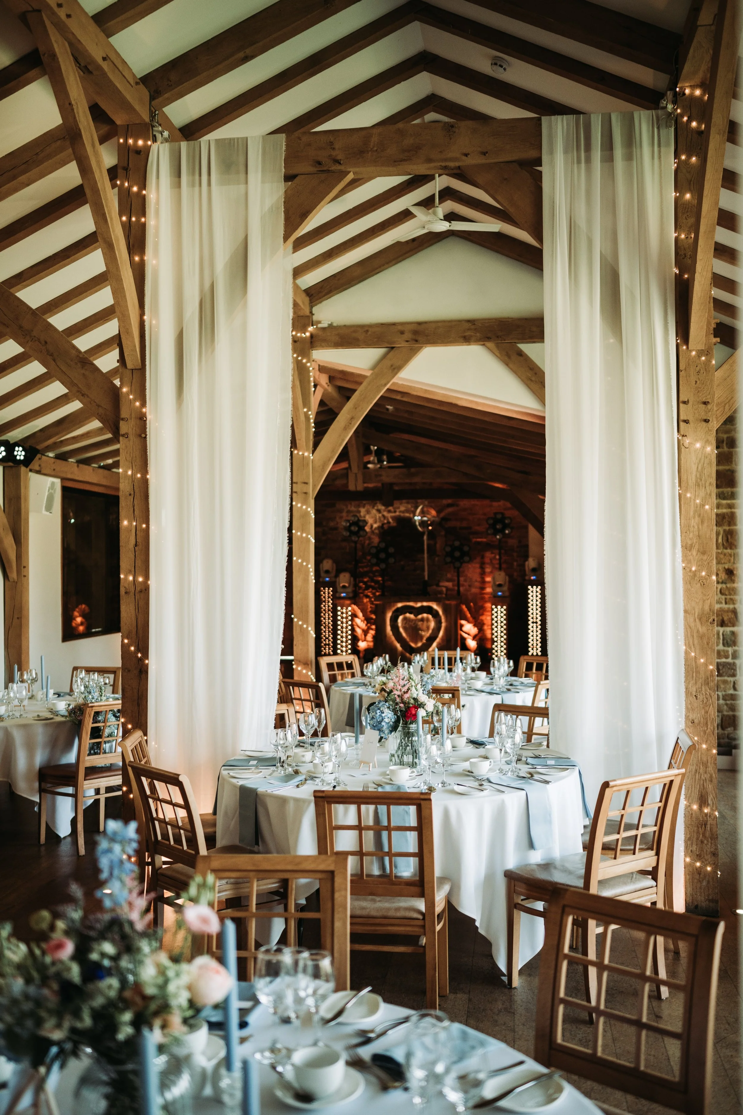 Dodford manor wedding reception DJ and drapes setup with tables
