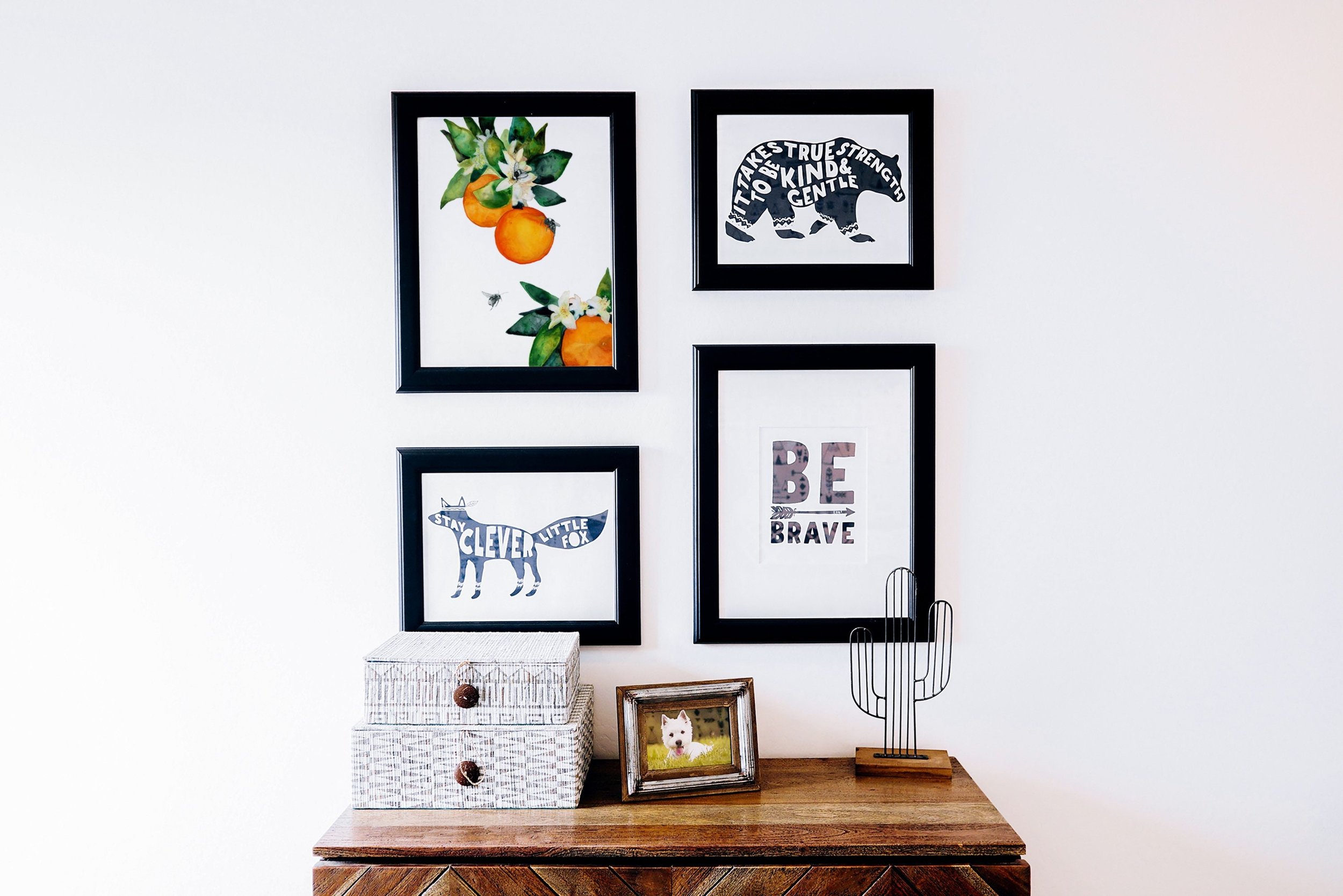 framed floral and nature watercolor prints hanging above a desk