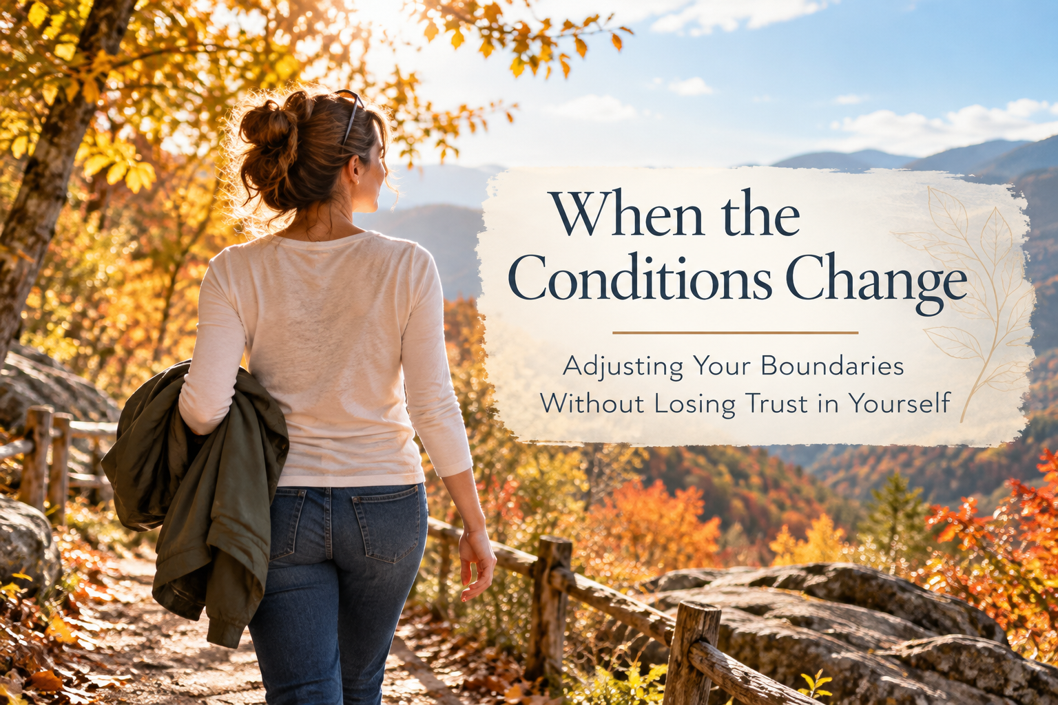 Woman walking on a mountain trail in autumn, carrying her jacket as the weather warms.