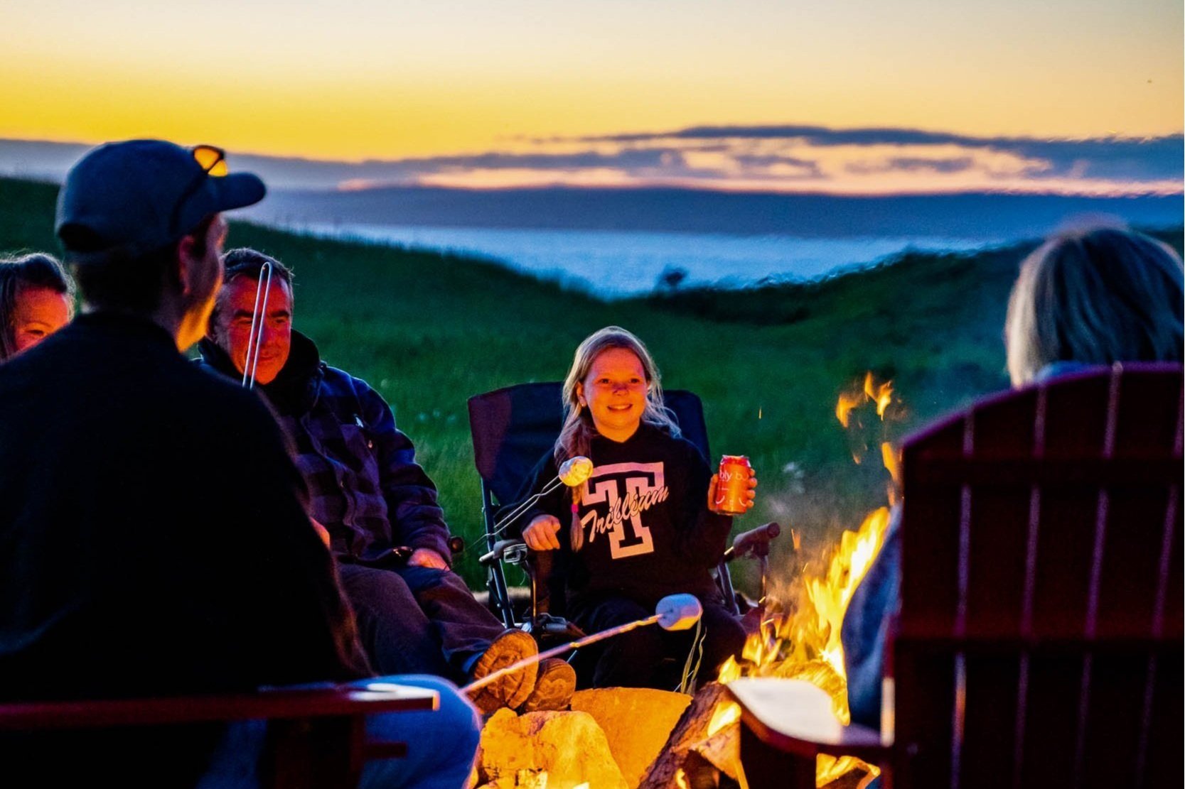 Alt text: A group of friends sitting around a campfire making S’mores.