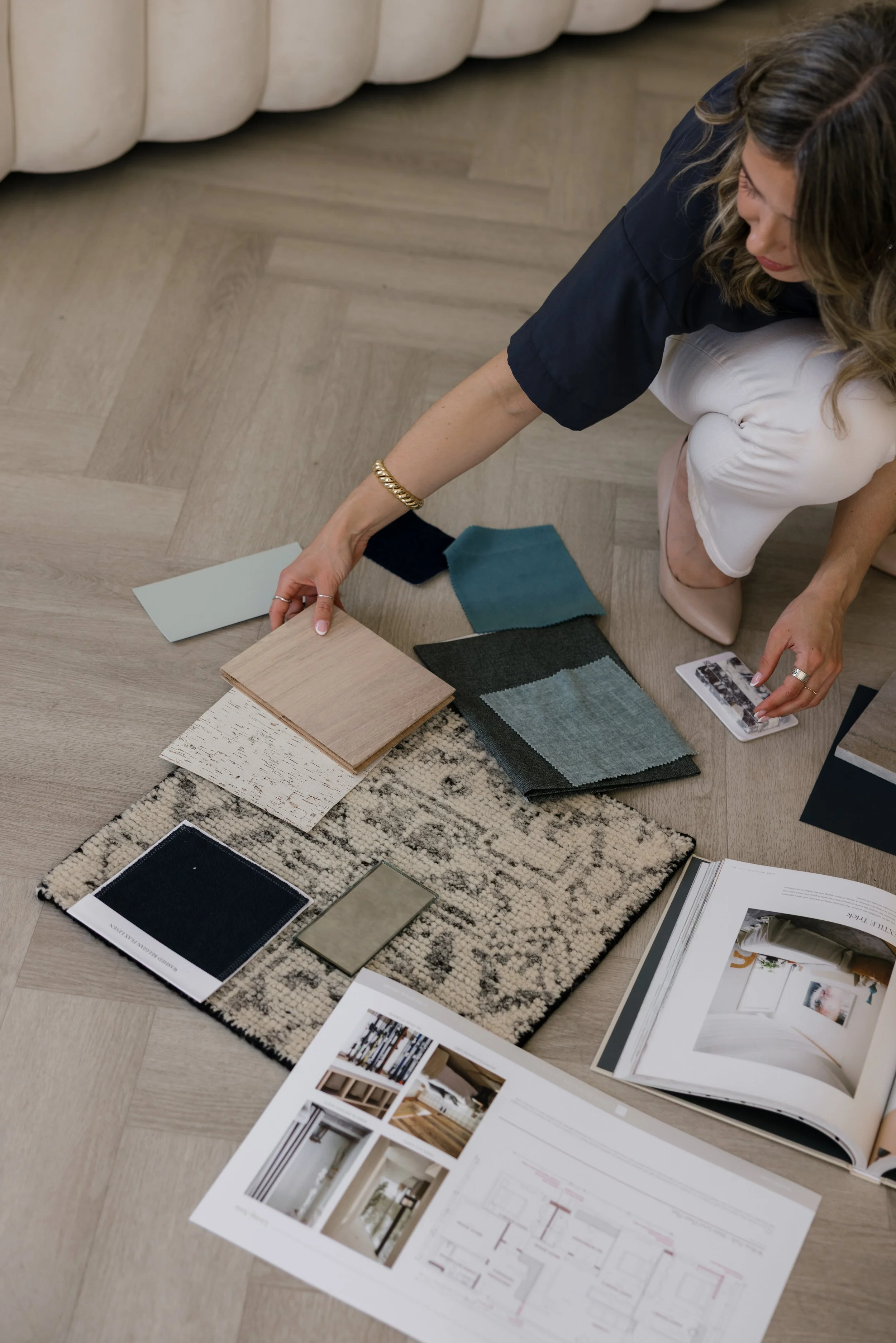 Leah Simpson selecting fabric swatches, wood flooring and tile samples for an online design consultation
