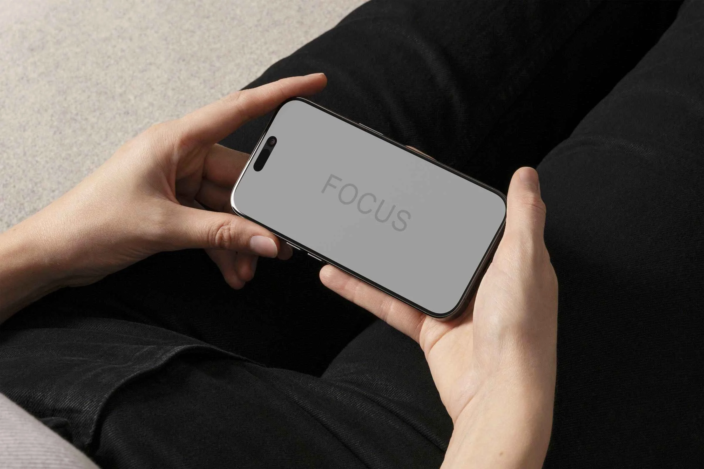 A person holding a smartphone displaying the word 'FOCUS', illustrating the Focused Brand System™ by DAS, a branding agency in London.