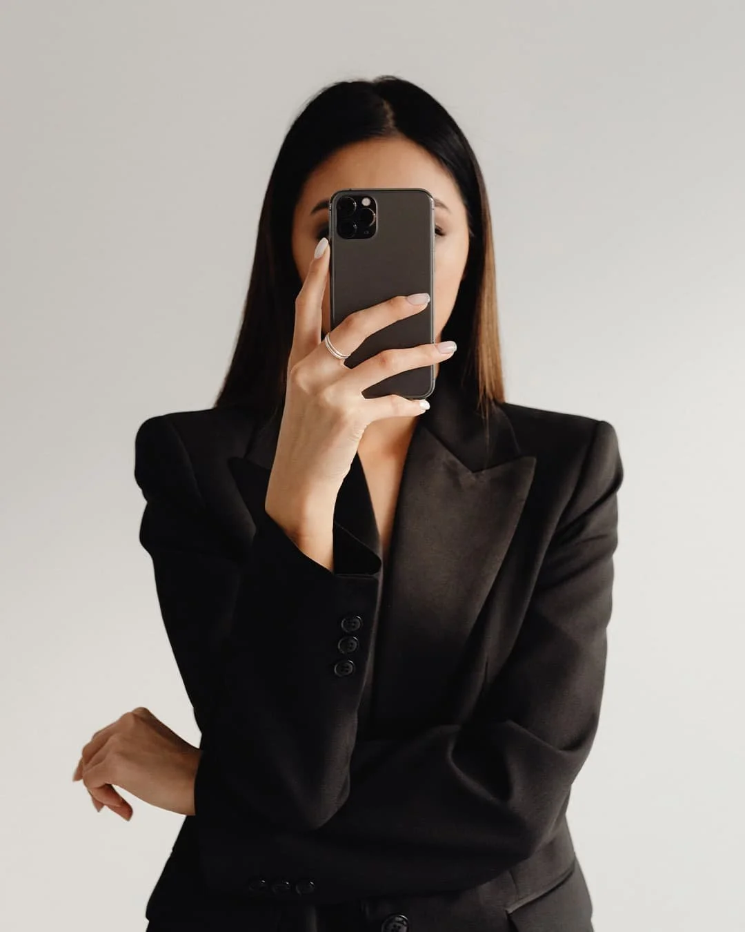 A high-end architectural interior featuring a professional in a minimalist, light-filled space using a smartphone, symbolizing digital visibility and modern brand presence.