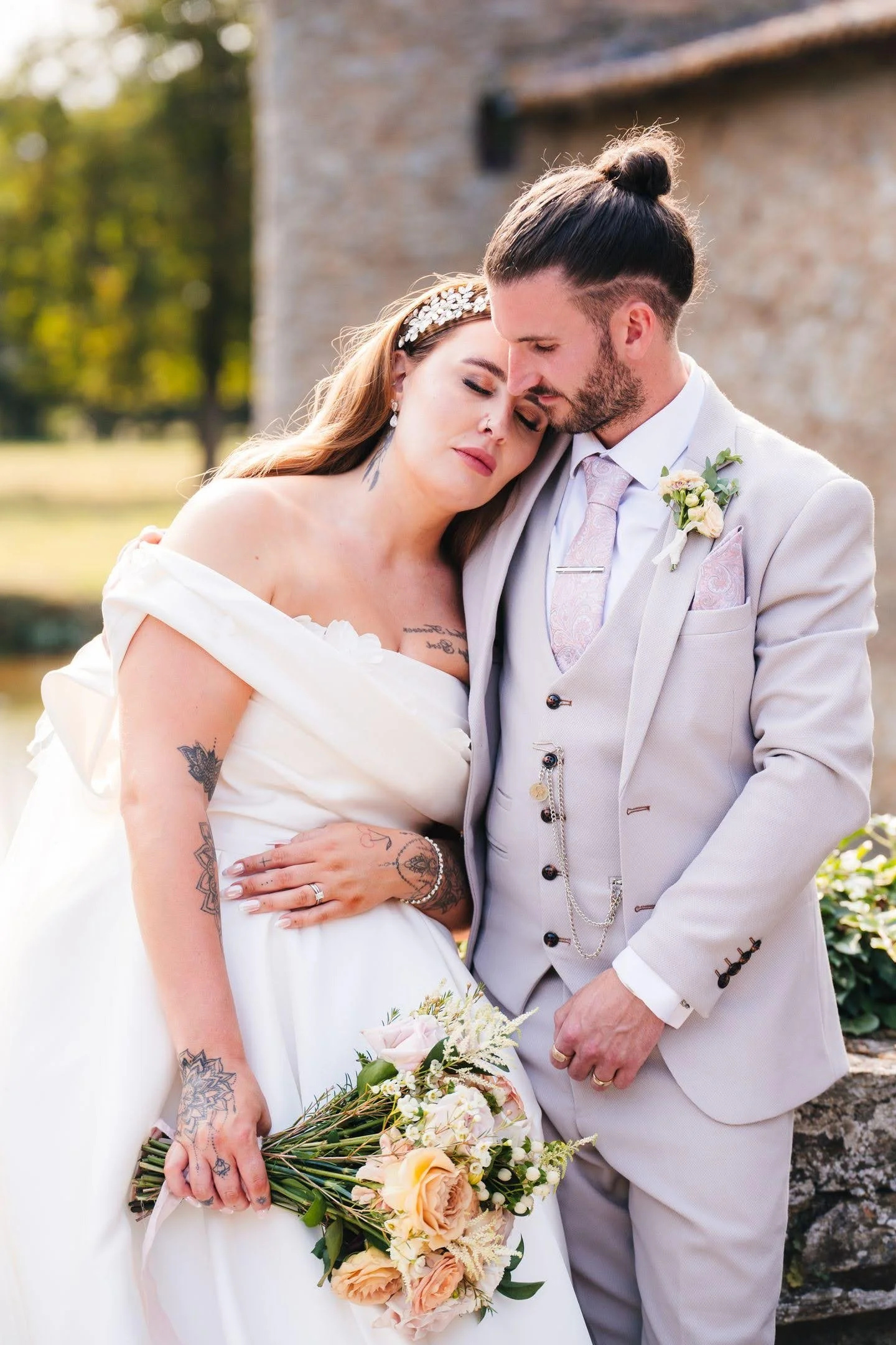 A bride and groom are alone in an intimate embrace while the chateau in france is in the background