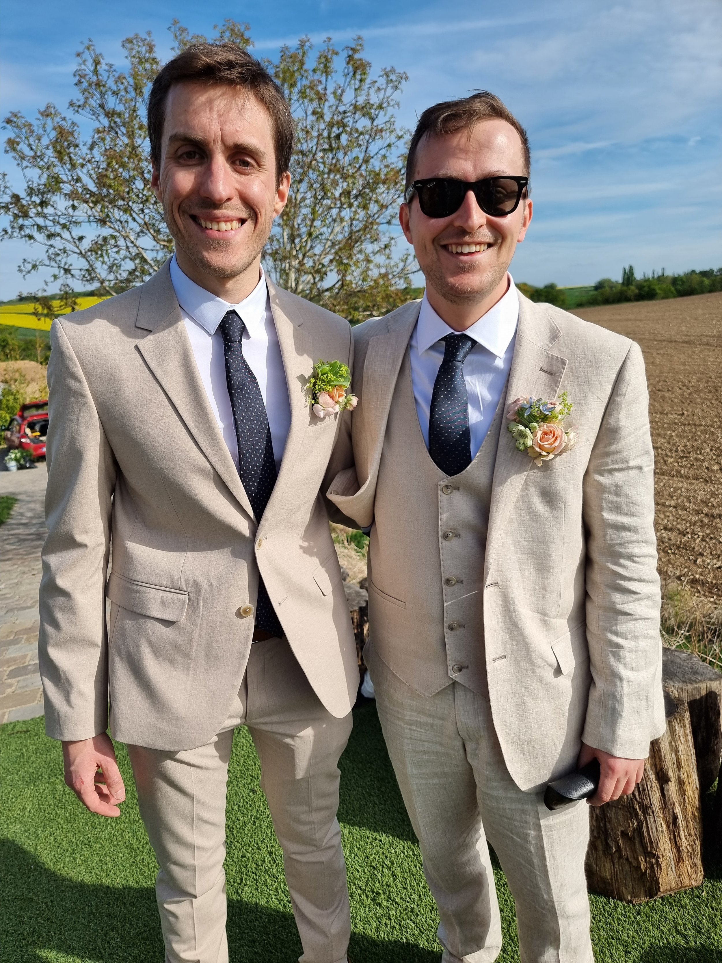 The groom and his groomsman stand with their boutonnieres waiting for the wedding to begin in April in France