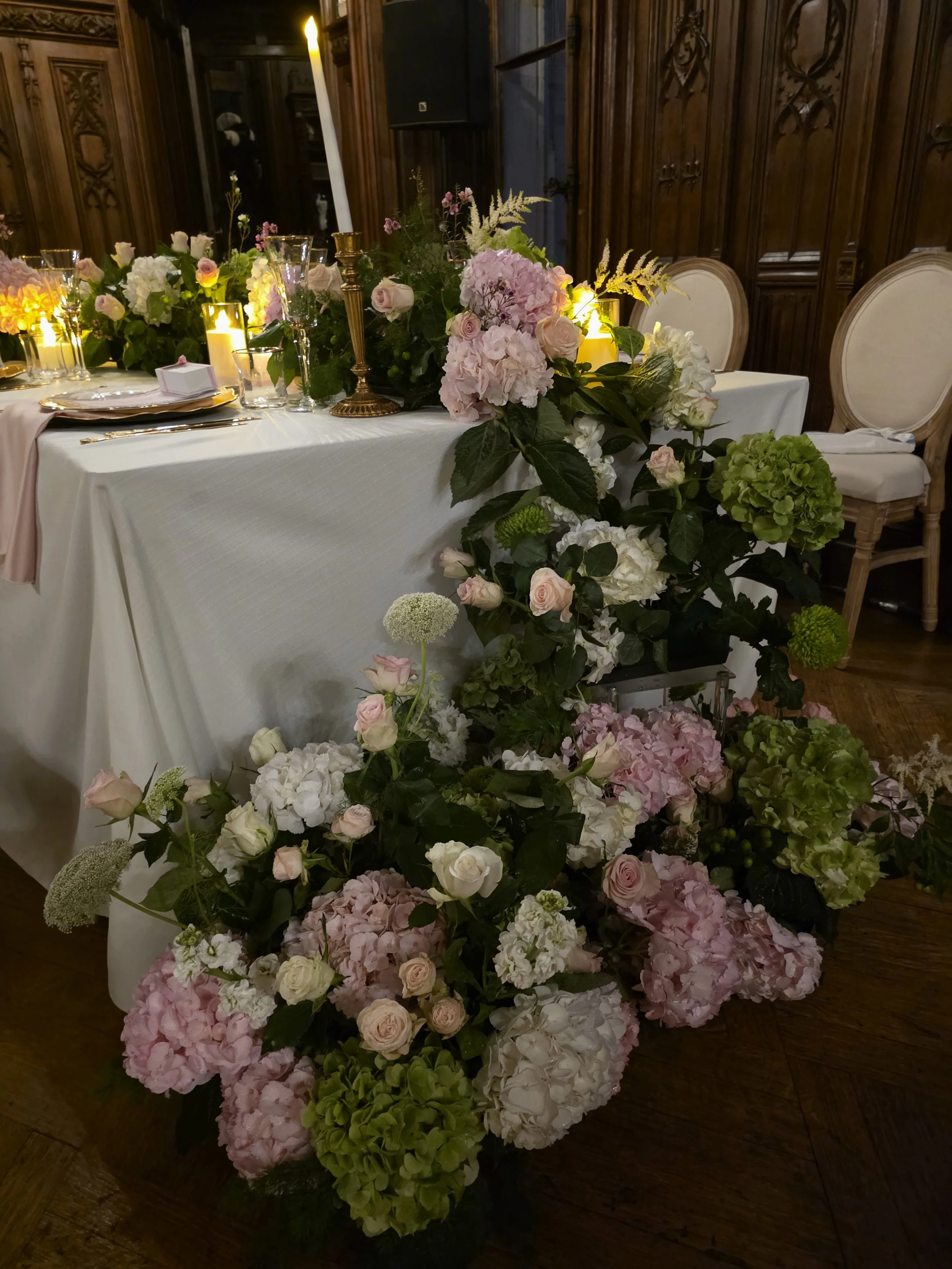 table filled with flowers and pink hydrangeas and candlelight for a wedding in a french chateau