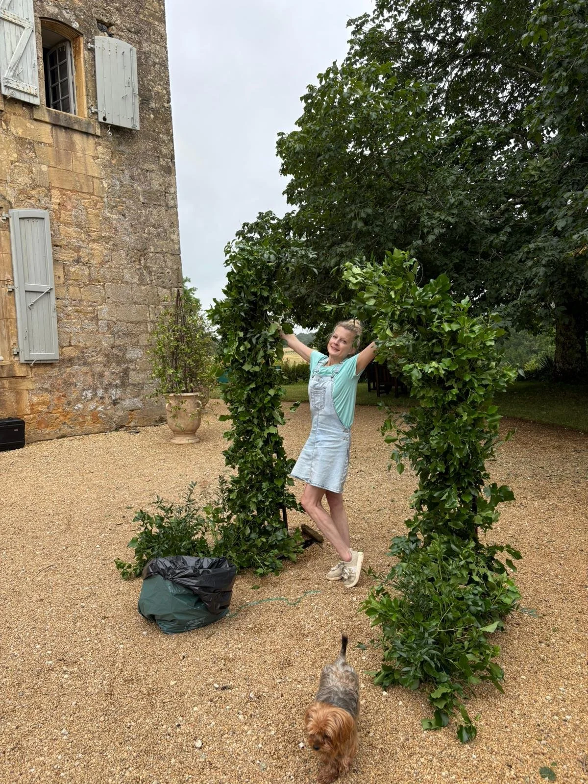 wedding florist at a chateau for a destination wedding in france standing in front of a floral arch in progress
