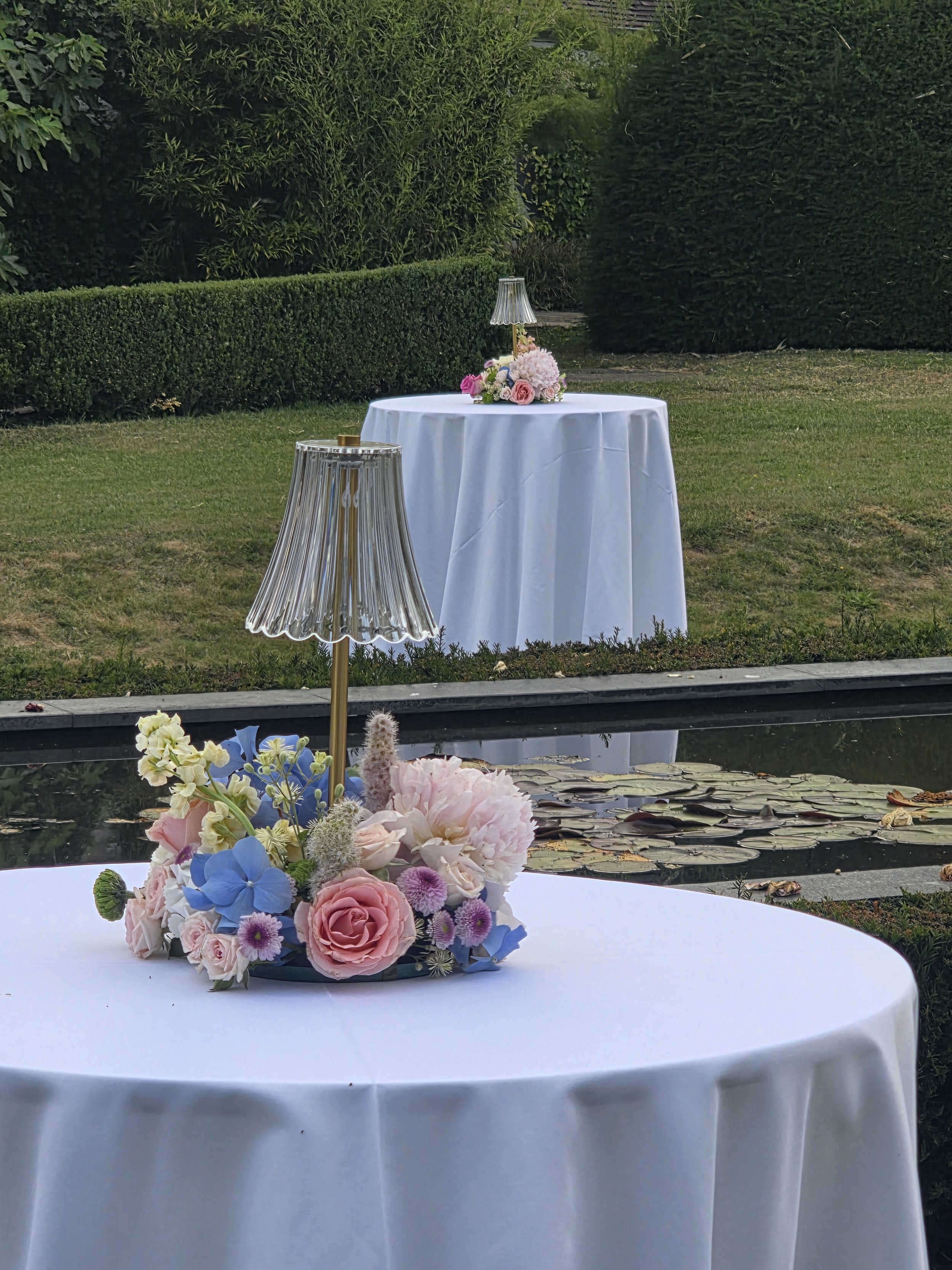 Rehearsal dinner party with small LED lamps encircled with flowers for cocktail tables.