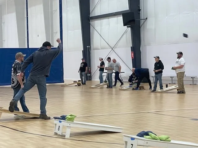 Man pitching bag during CVIM 2025 Cornhole event