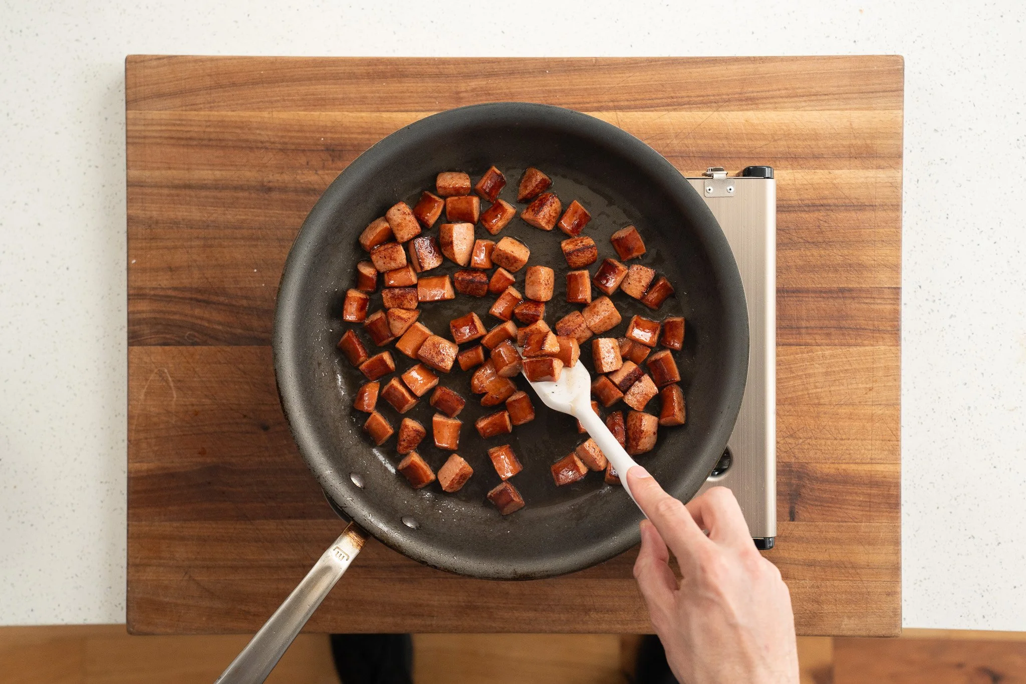 browning andouille sausage in a nonstick pan