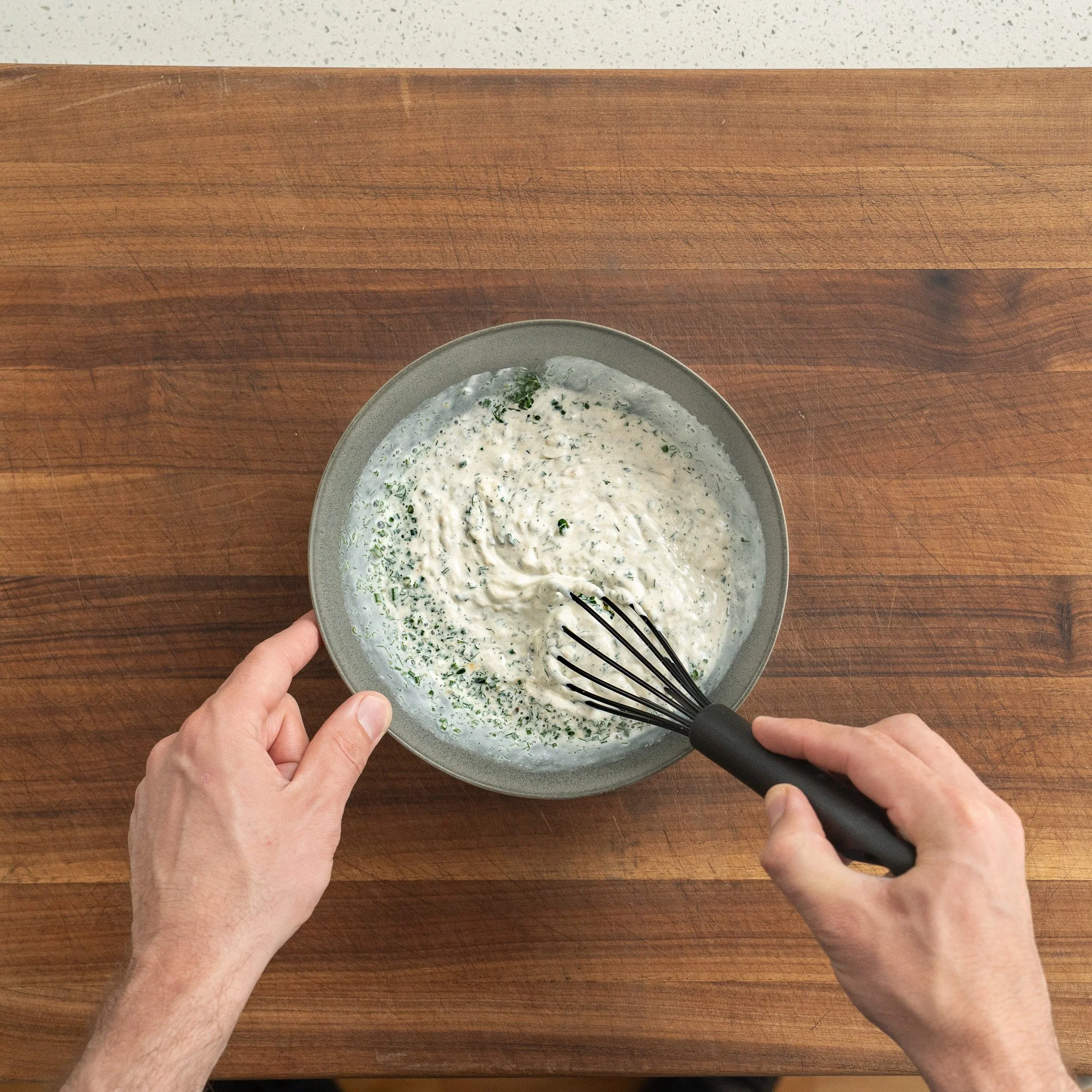 whisking together blue cheese dressing in a gray bowl