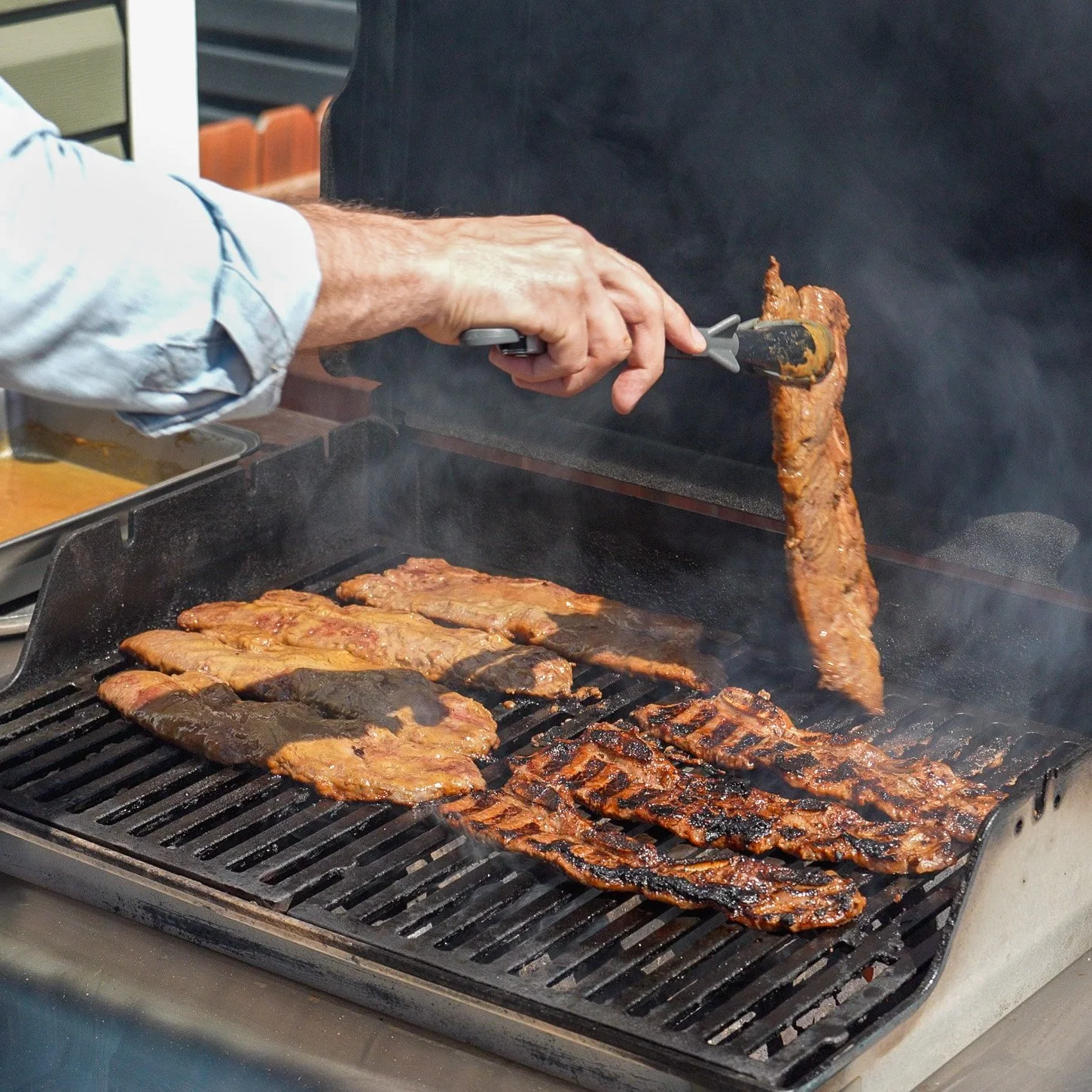 flipping korean short ribs on a grill