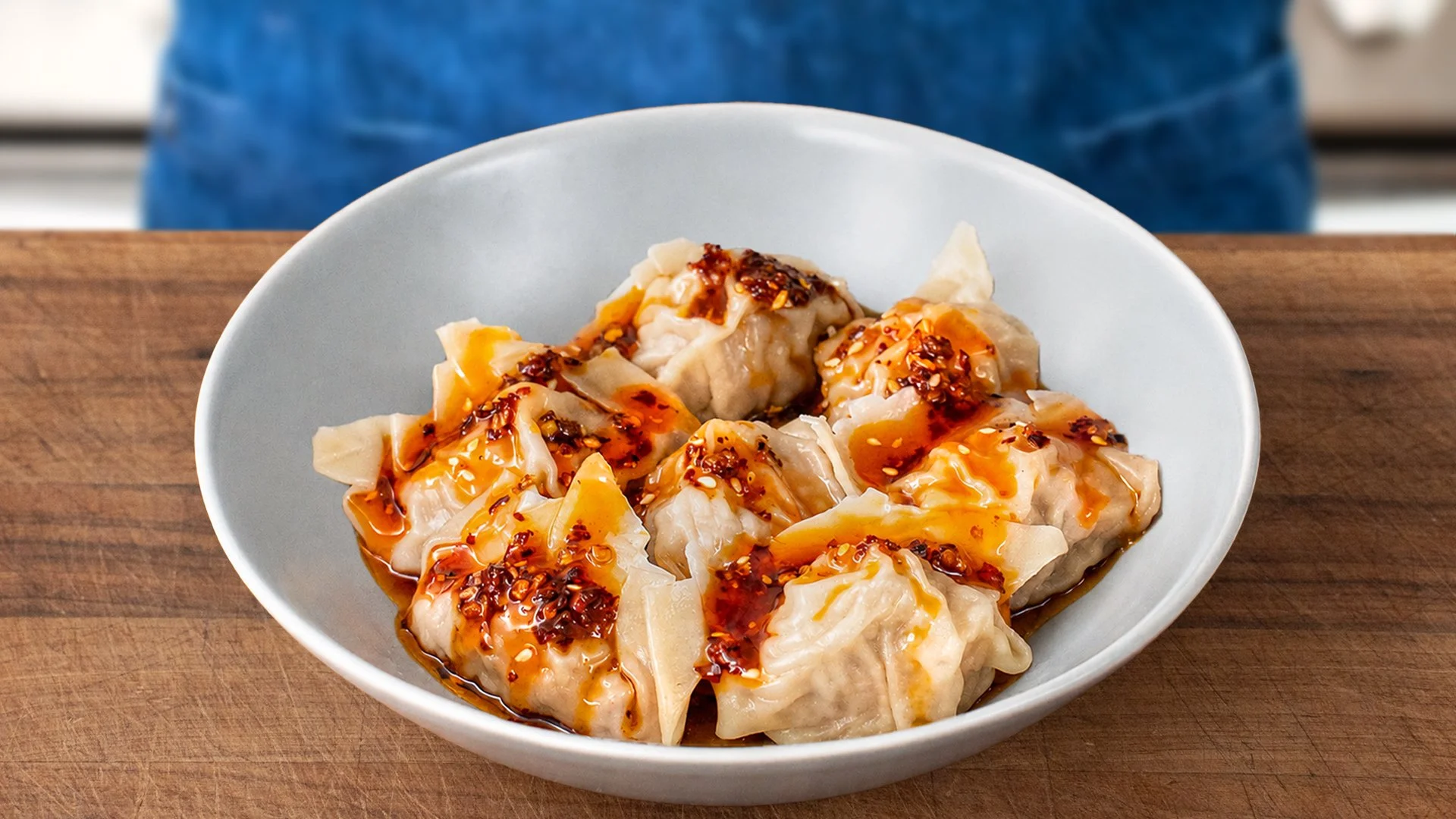 grey bowl of chili oil glazed wontons
