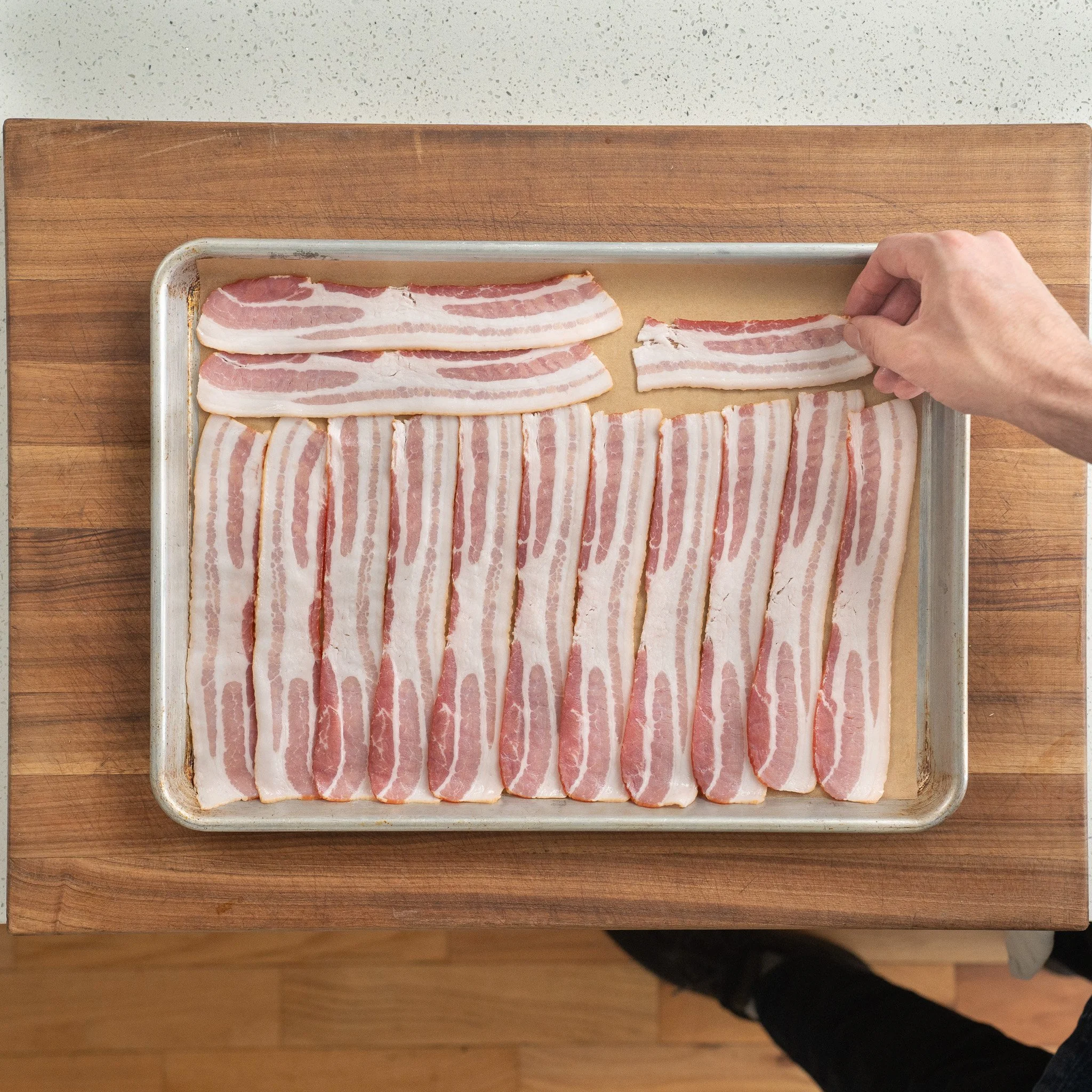 slices of bacon arranged on a sheet tray