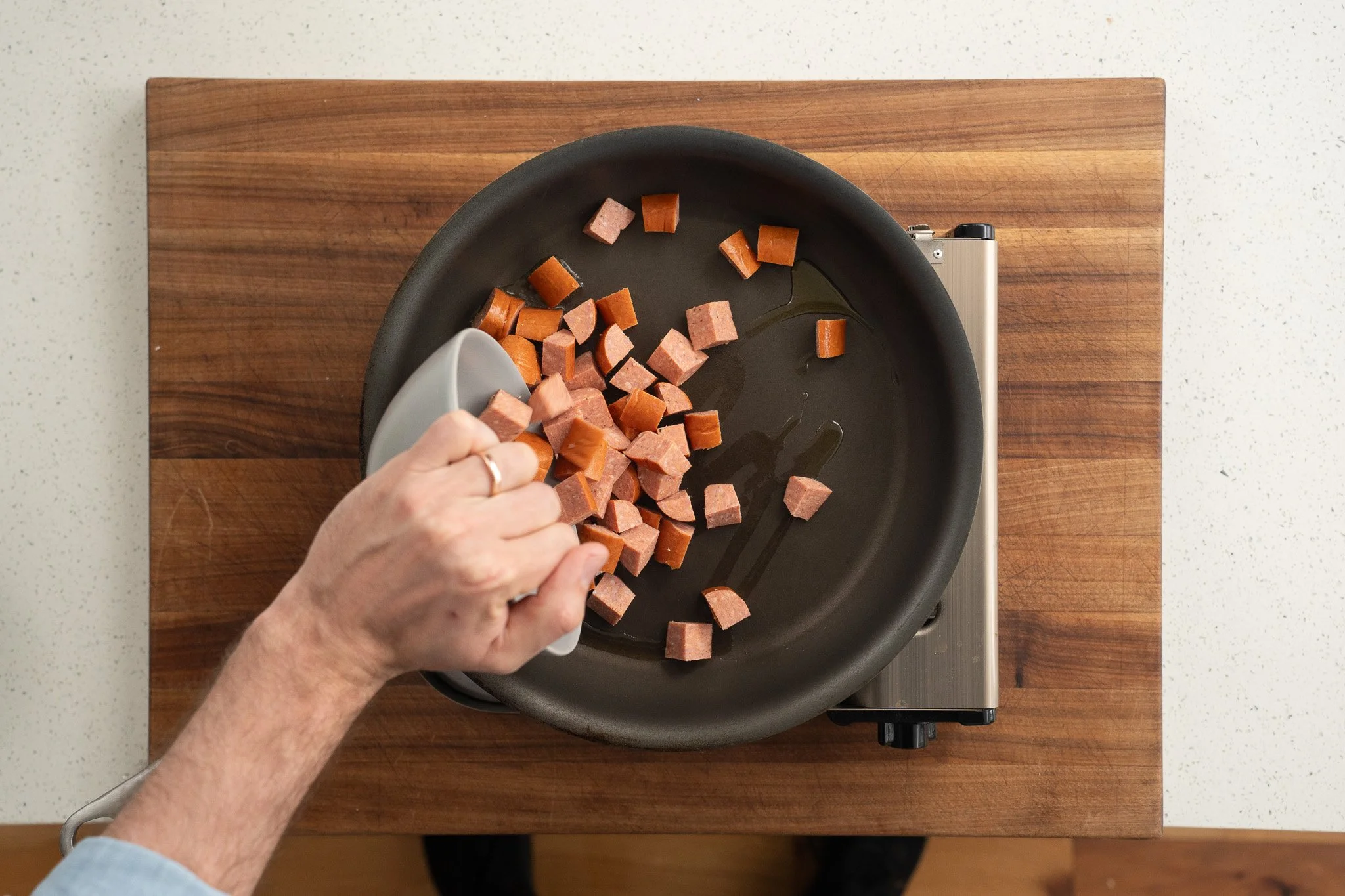 adding andouille sausage to a nonstick pan