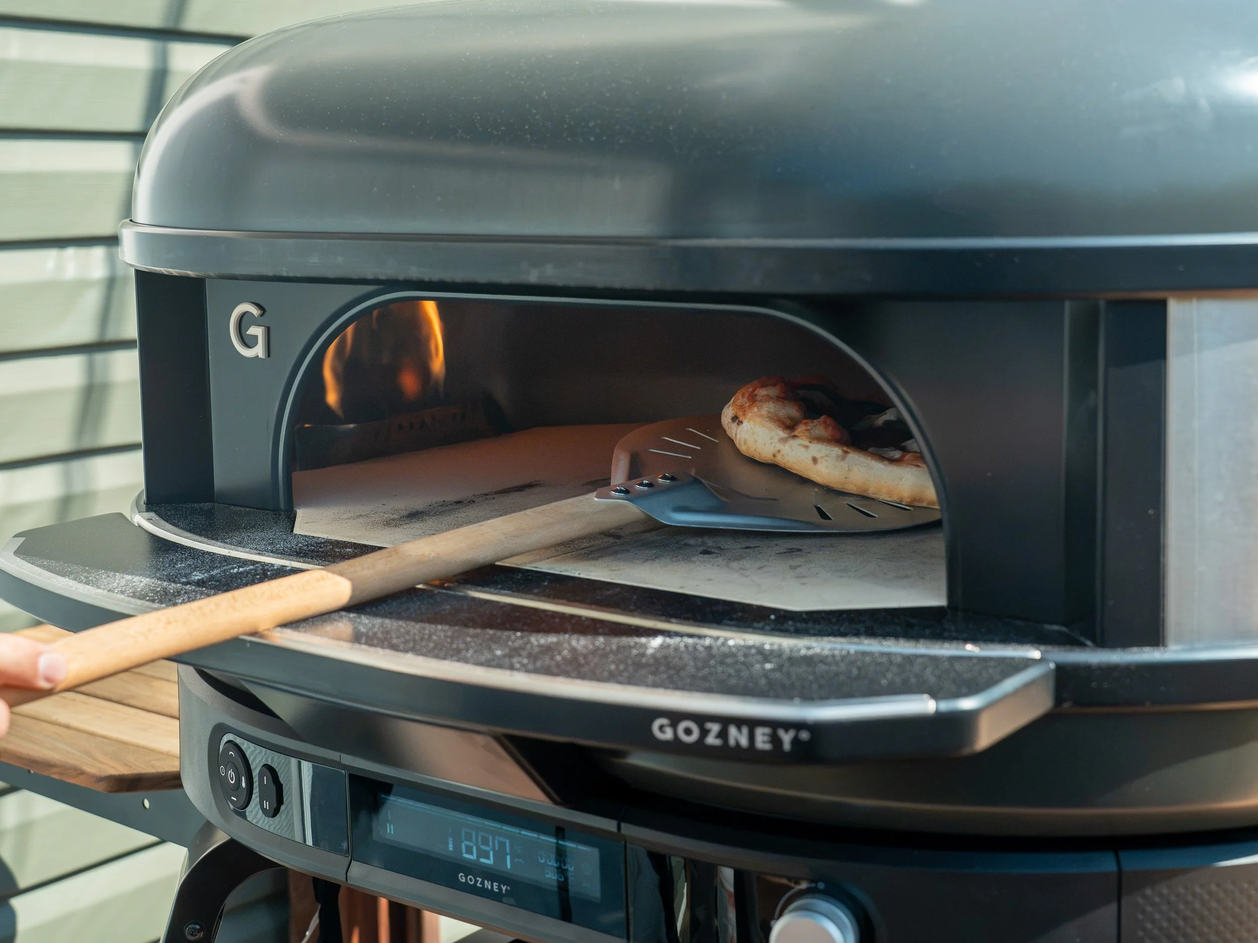 rotating neapolitan pizza in pizza oven with turning peel