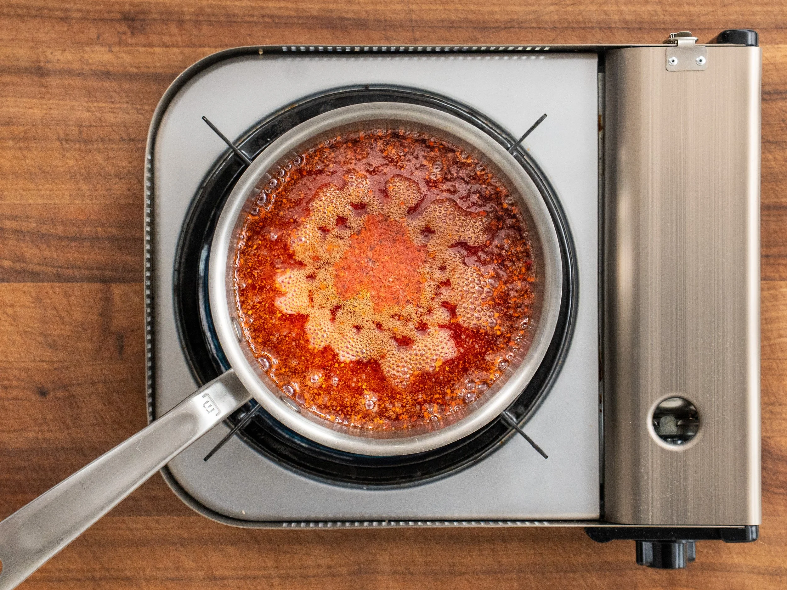bright red boiling liquid in a sauce pot