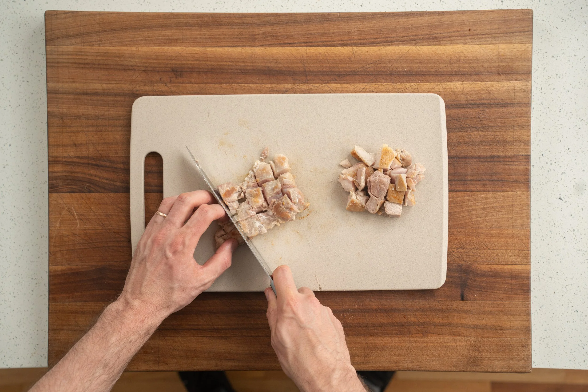 dicing chicken thighs on a cutting board