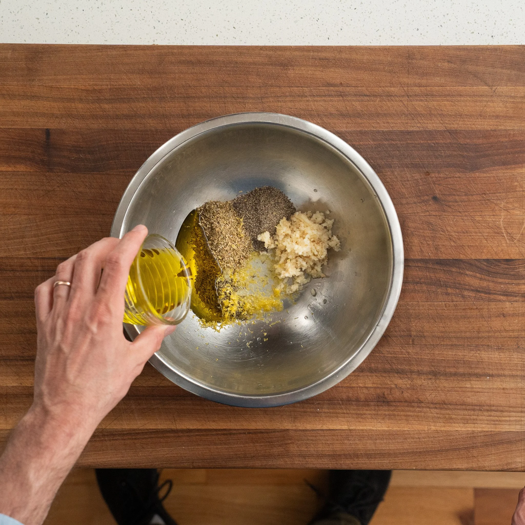 combining olive oil garlic and spices in a bowl for marinade