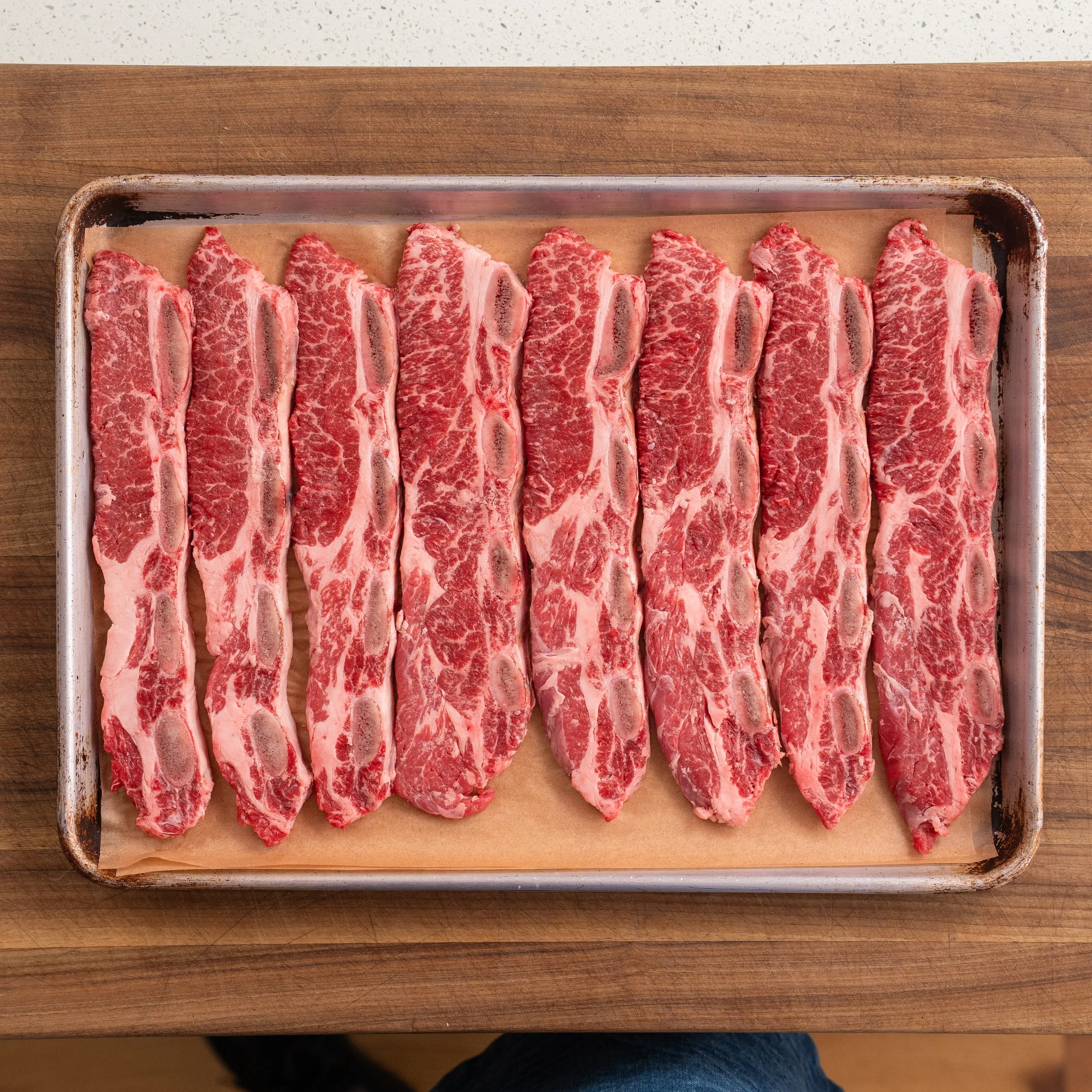 raw Korean short ribs on a sheet tray