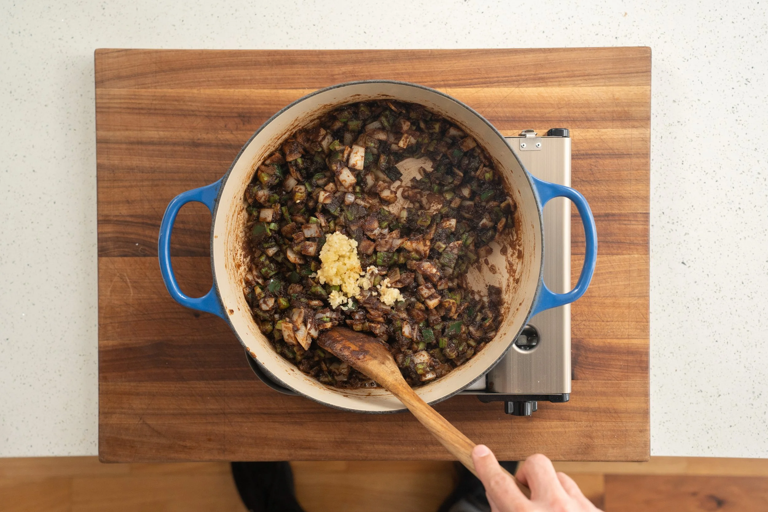 adding garlic into gumbo trinity and roux