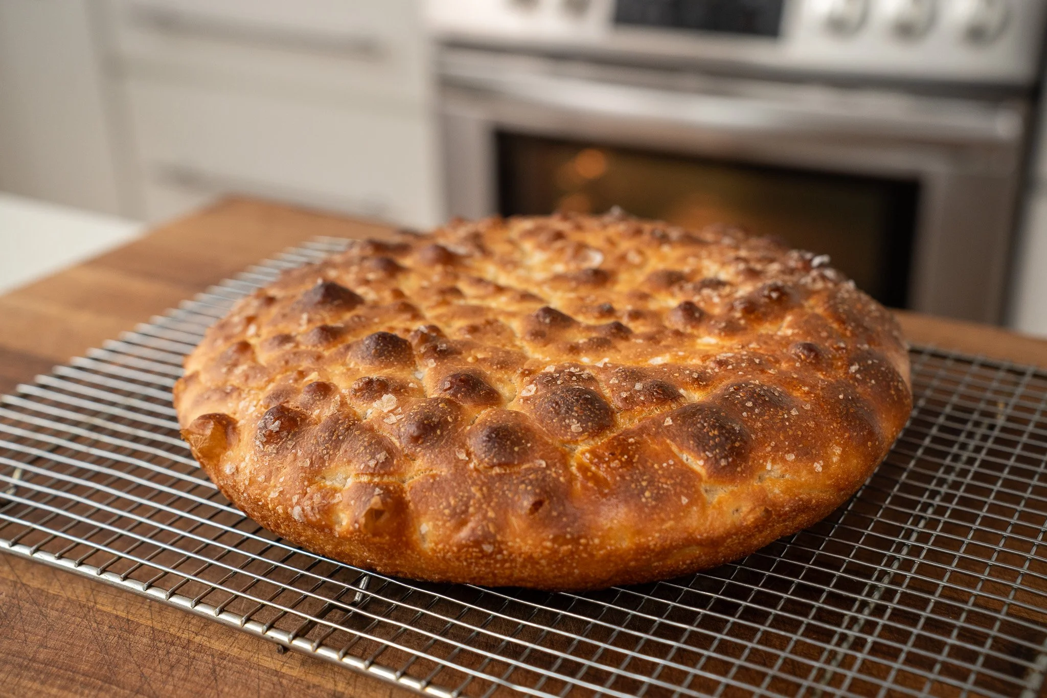 Beautifully baked focaccia loaf cooling on a wire rack