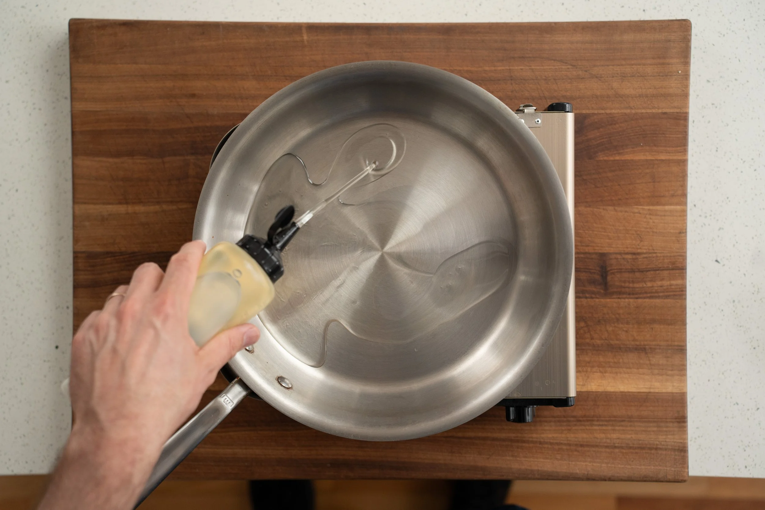 adding neutral oil to a saute pan