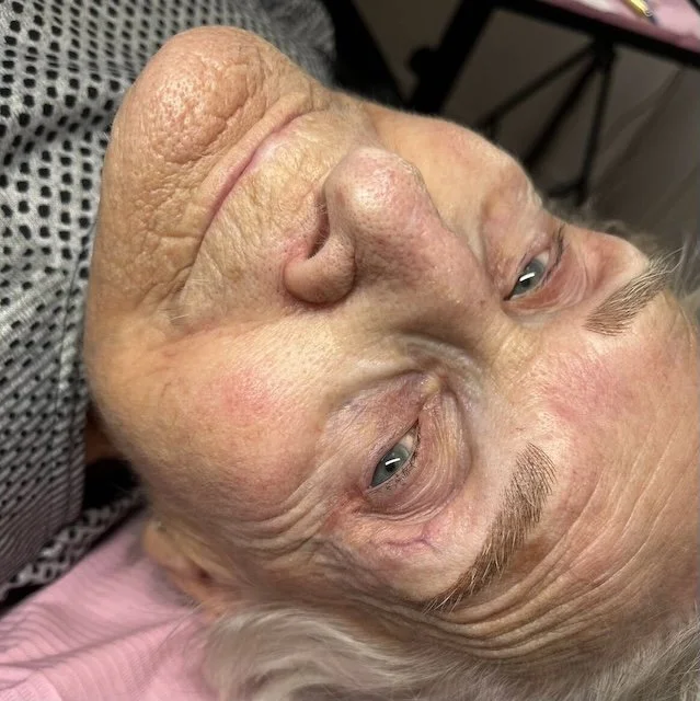 Close-up of a mature woman with permanent makeup brows featuring soft, natural-looking hair strokes.