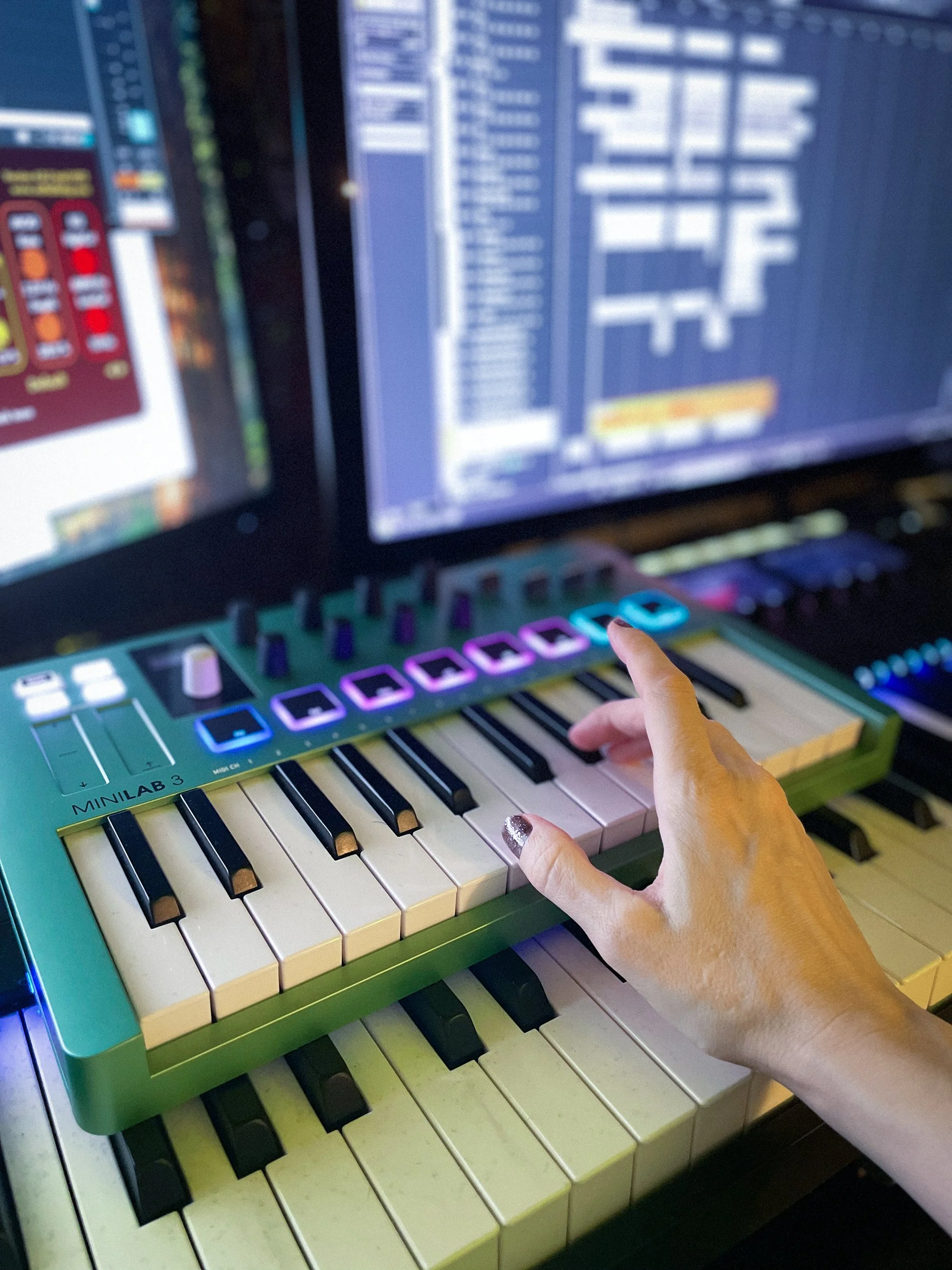 Emilie's hand playing a keyboard in a recording studio
