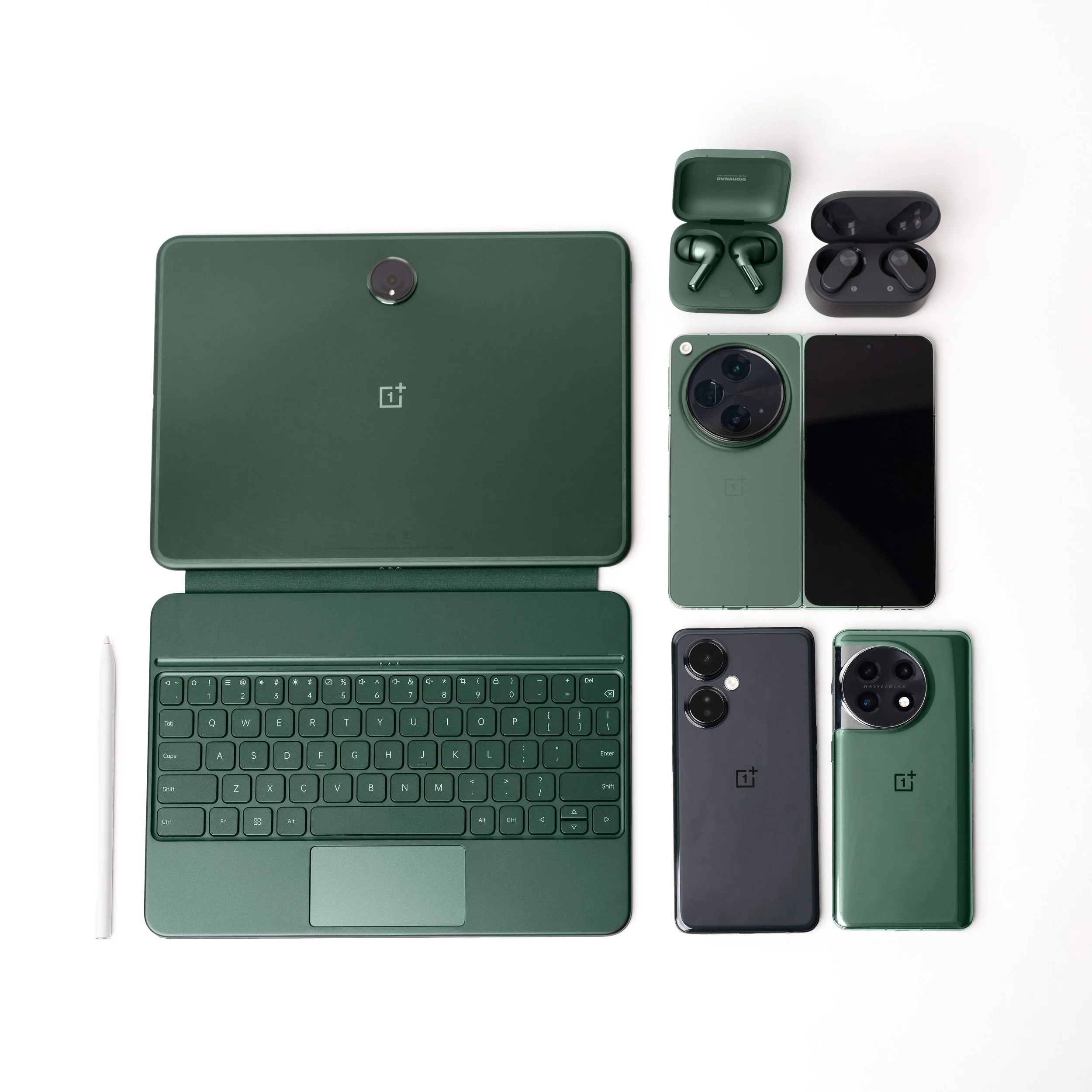 A collection of modern electronic devices in green and black colors, including a tablet, smartphone, wireless earbuds case, wireless earbuds, a keyboard, and a stylus, arranged on a white surface.