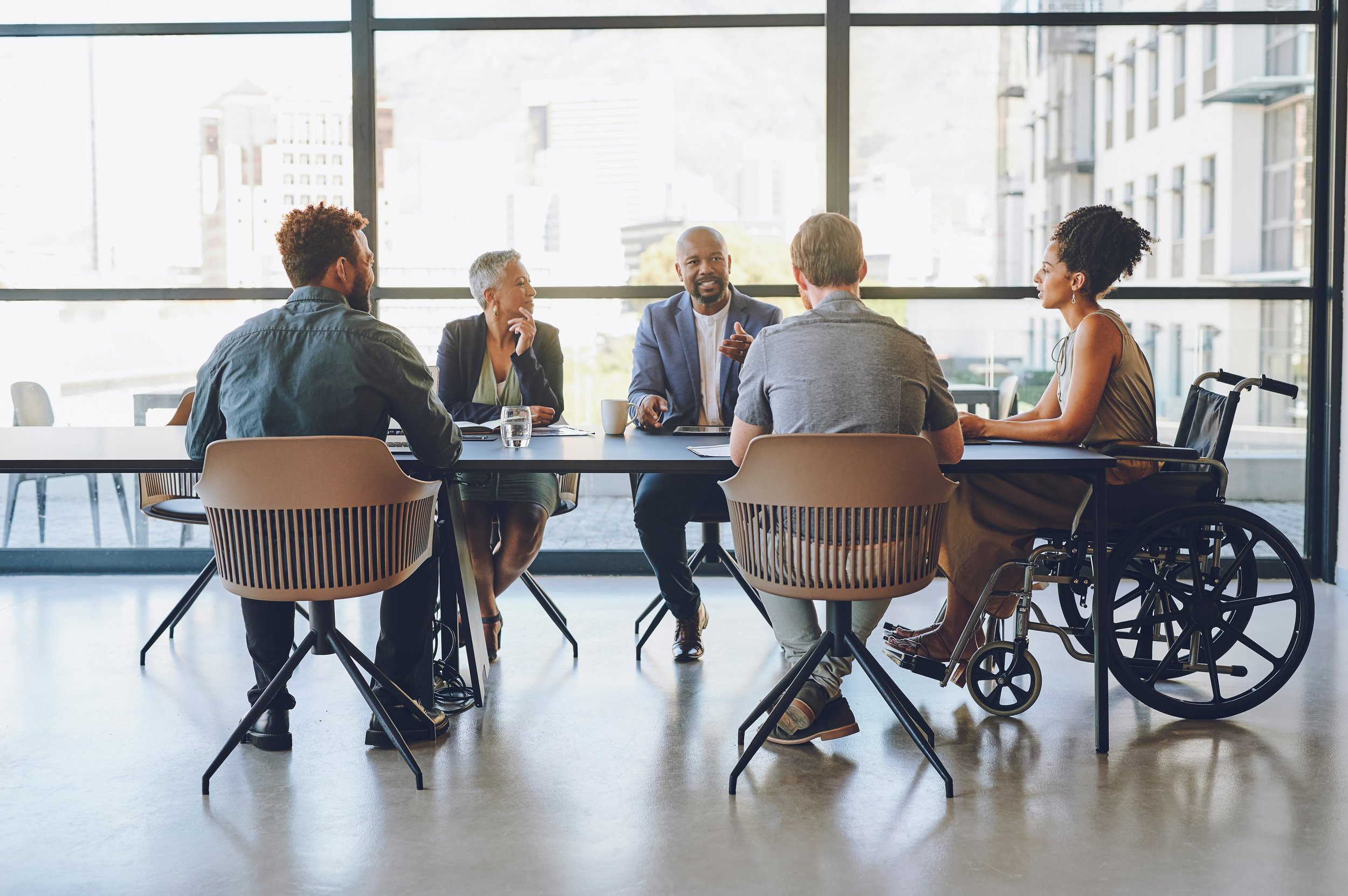 A group of people sit at a conference table to discuss a project.