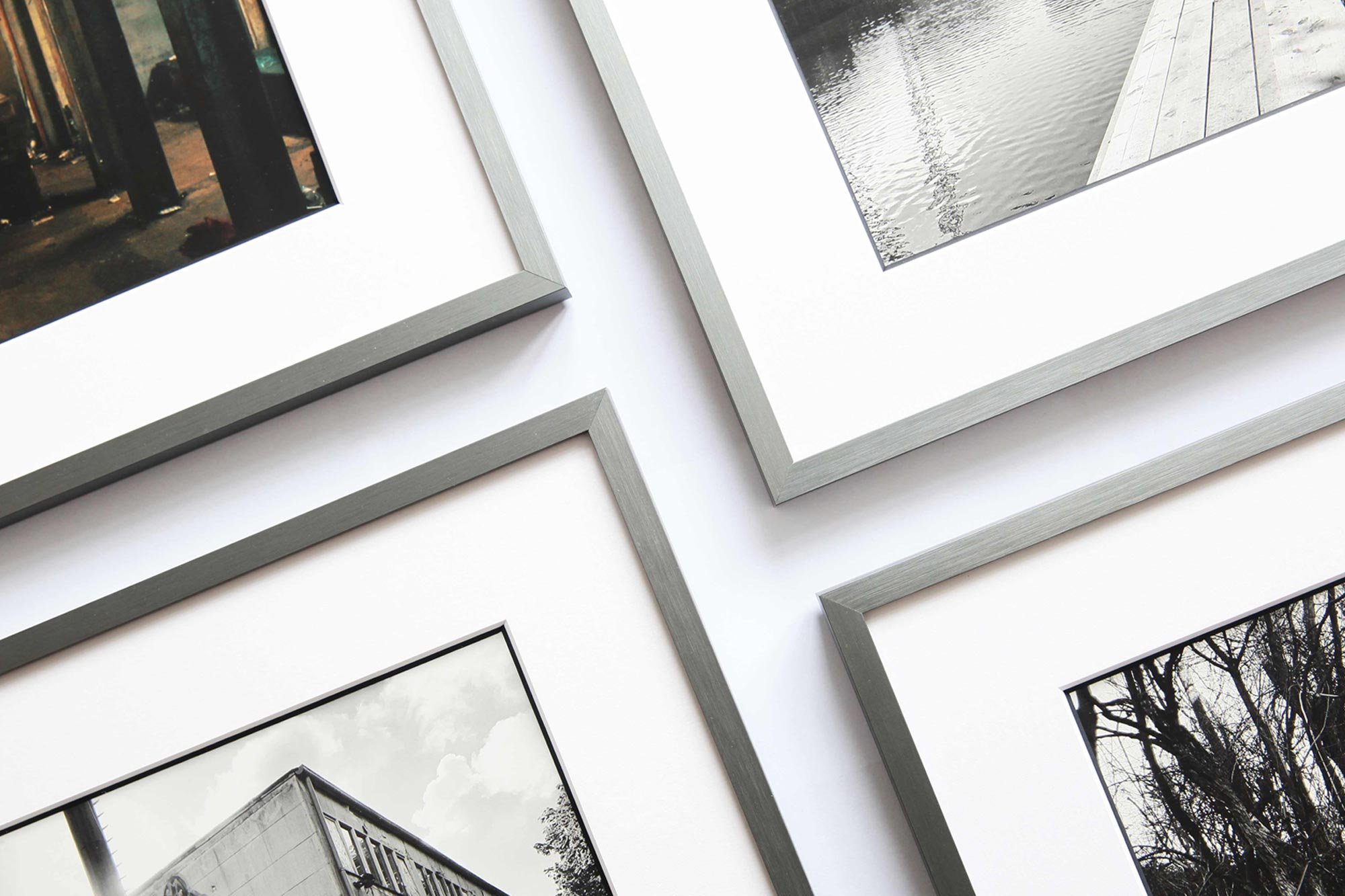 Fotografien in Metallrahmen mit weißen Passepartouts. Manche Passepartouts haben farbige Kontrastkanten.