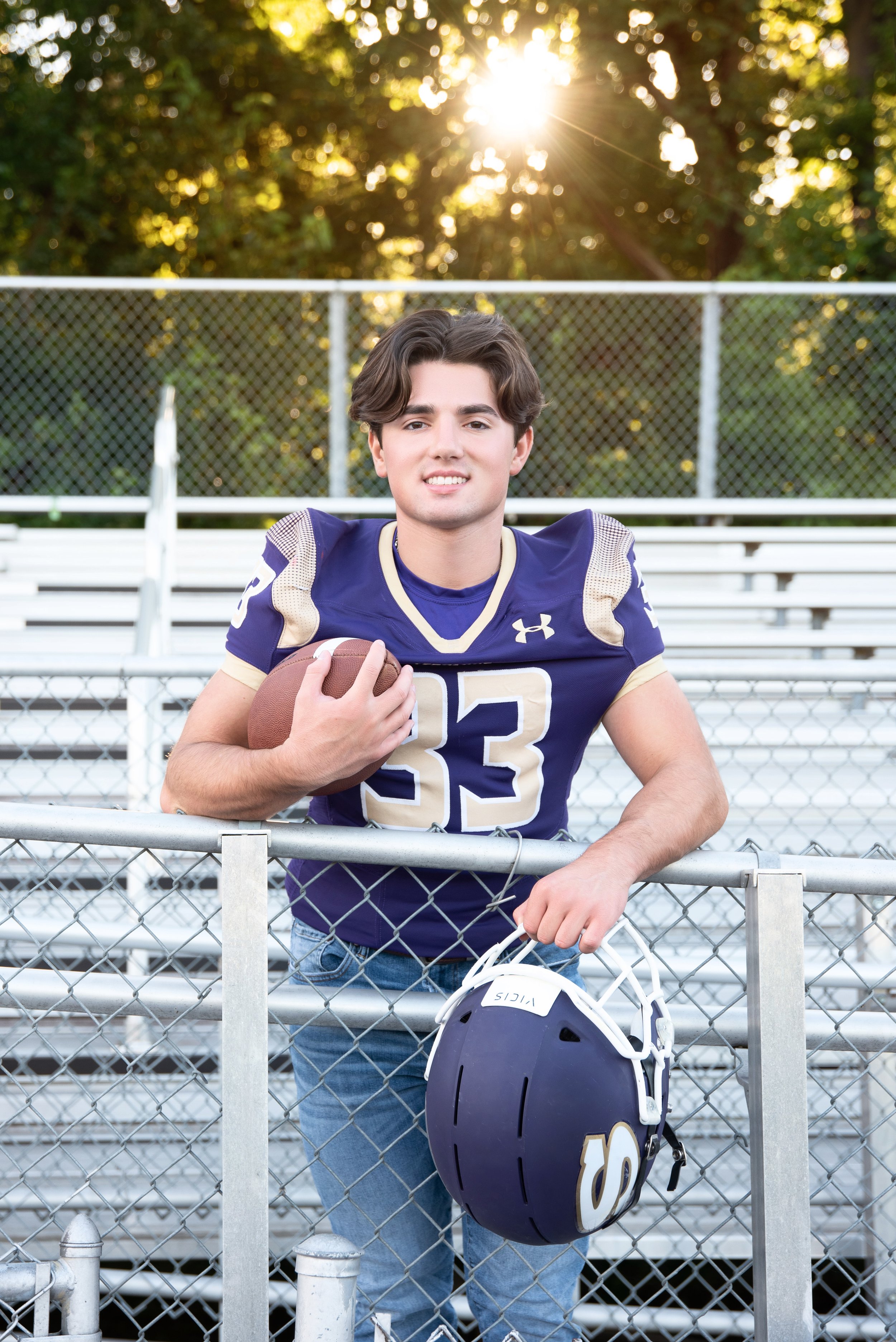 High school football senior portrait in uniform on the football field in Winchester, Virginia