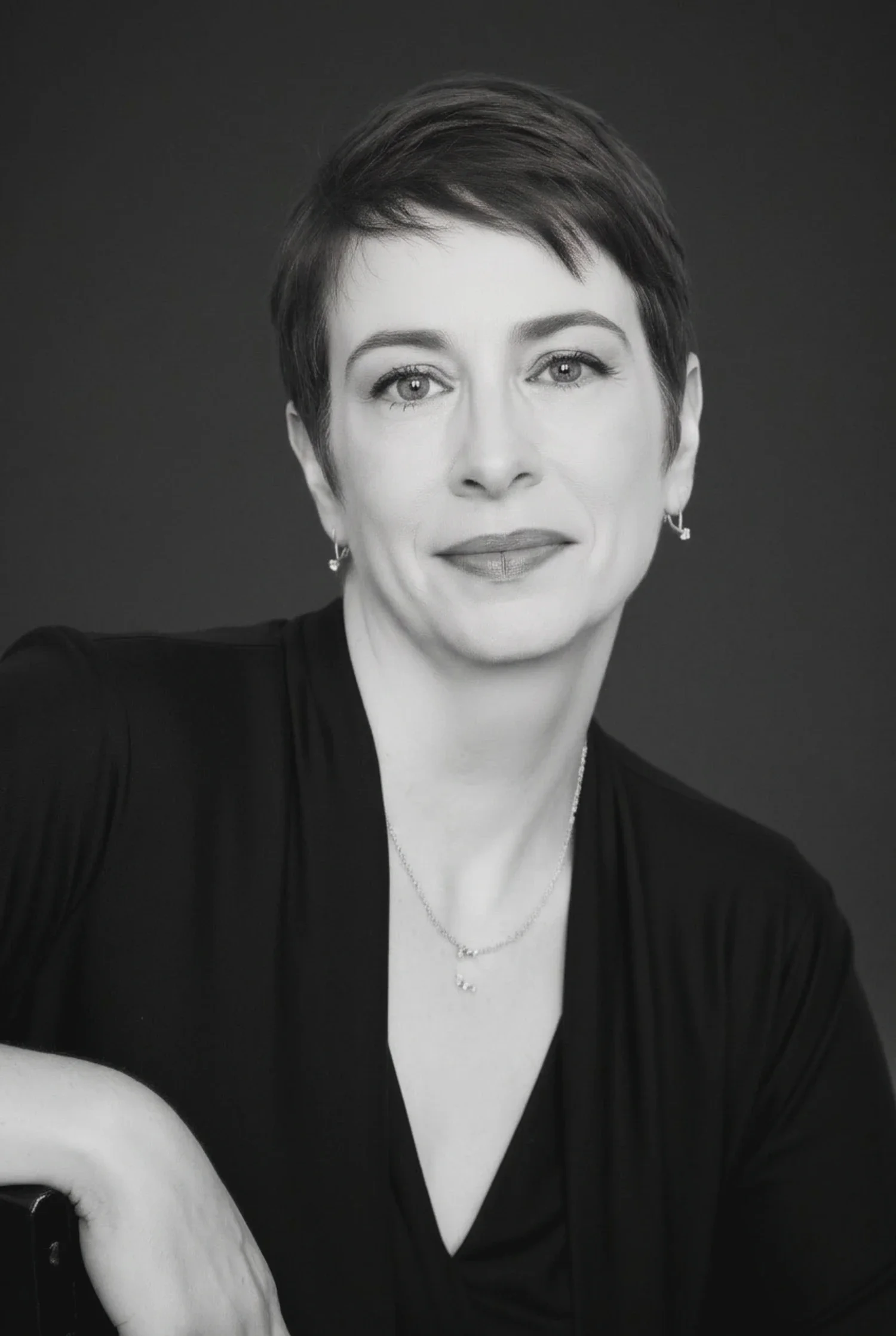 Meg Desjarlais in a composed close-up portrait with a slight smile — black and white.