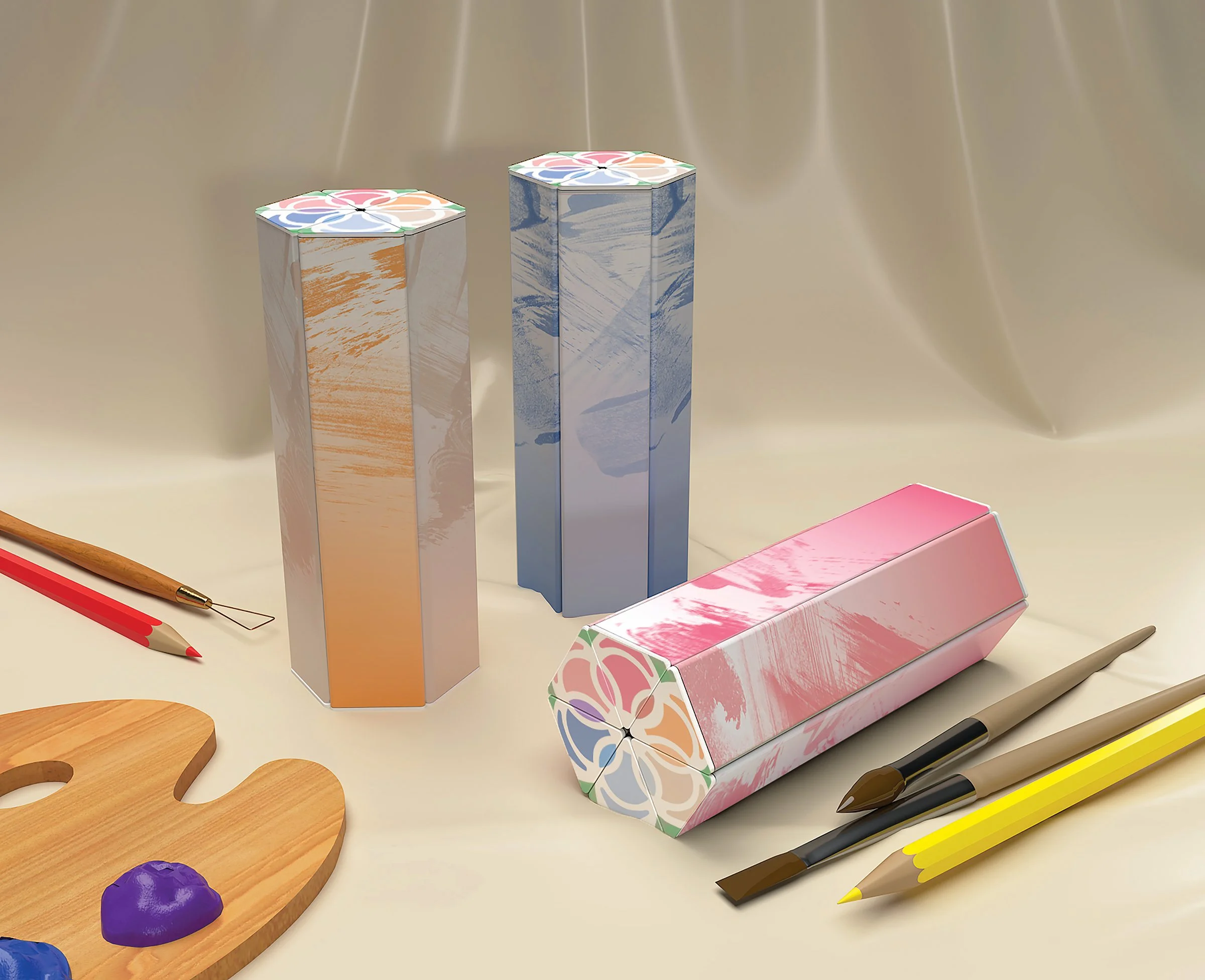 A fabric scene with three hexagon tube supply packages and pencils, clay tools, and brushes
