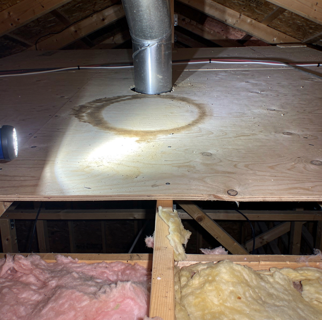 dark water stain on attic plywood near chimney