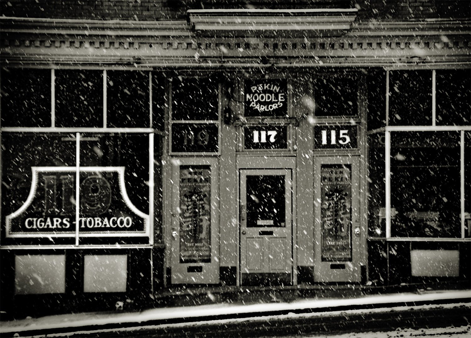 Black and White picture of the Pekin Noodle Parlor in Butte Montana. Snow is falling. 