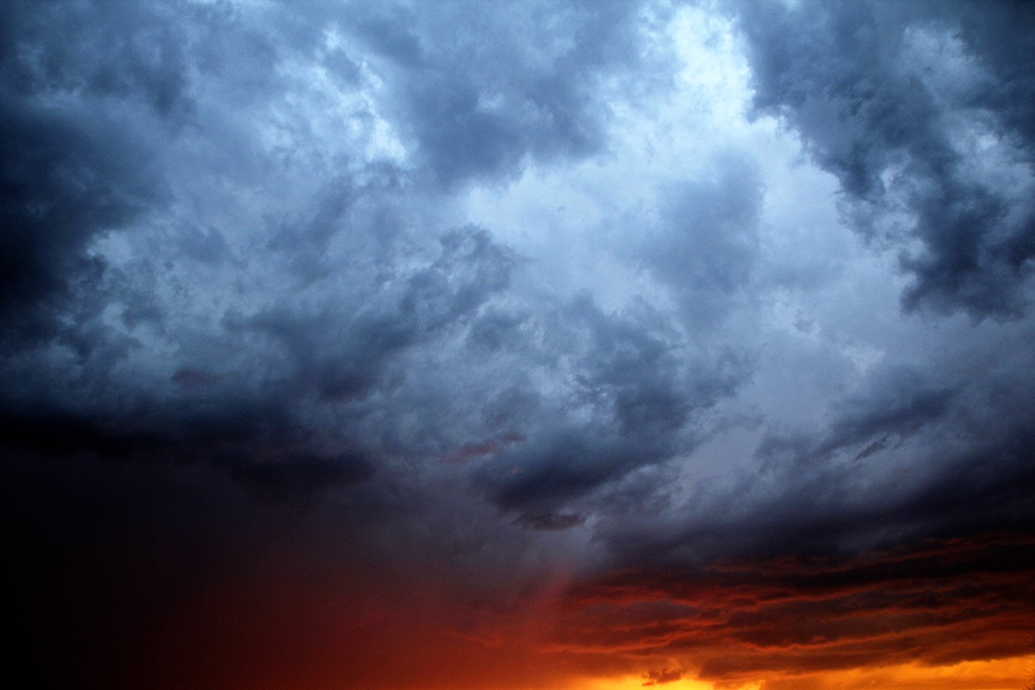 Black and dark grey stormy sky and a red fiery sunset. Townsend Montana. 