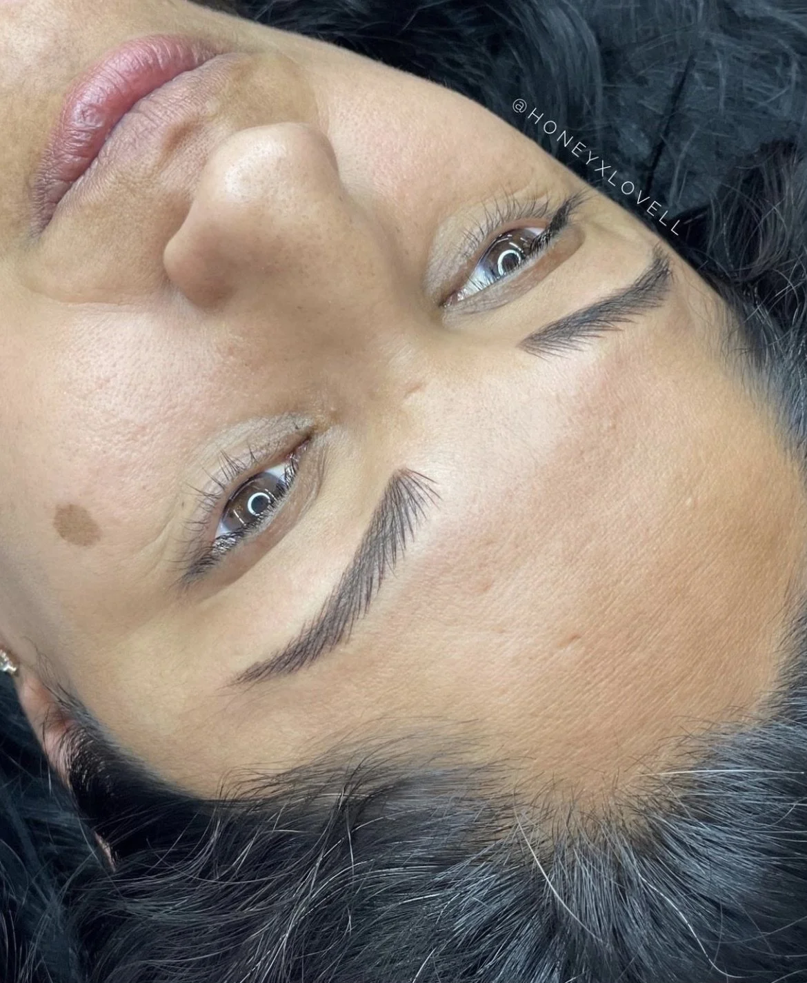 Close-up of a person's face, showing details of their eyes, eyebrows, nose, lips, and skin texture.