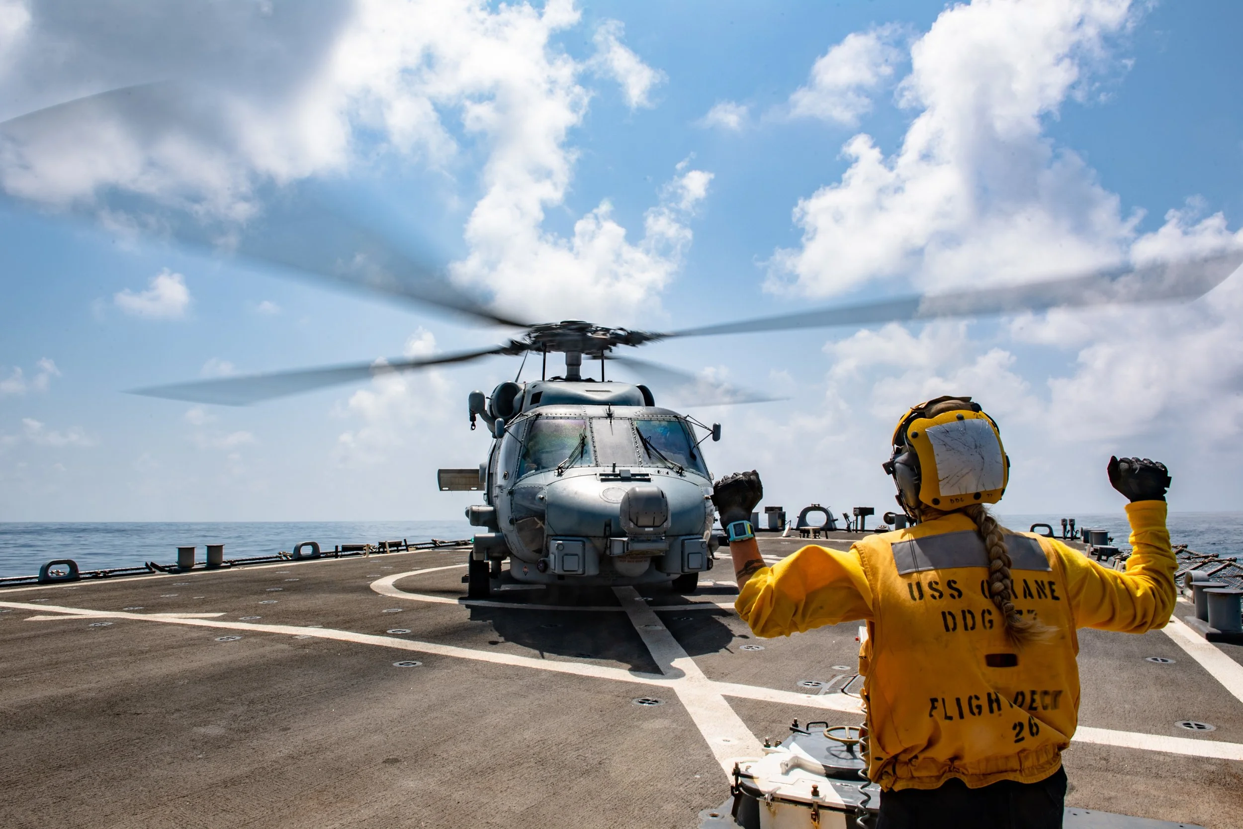  ARABIAN SEA (Sept. 27, 2021) Seaman Kathleen Mantooth signals an MH-60R Seahawk helicopter, attached to the “Easy Riders” of Helicopter Maritime Strike Squadron 37 (HSM-37), landing on the flight deck of guided-missile destroyer USS O’Kane (DDG 77) 
