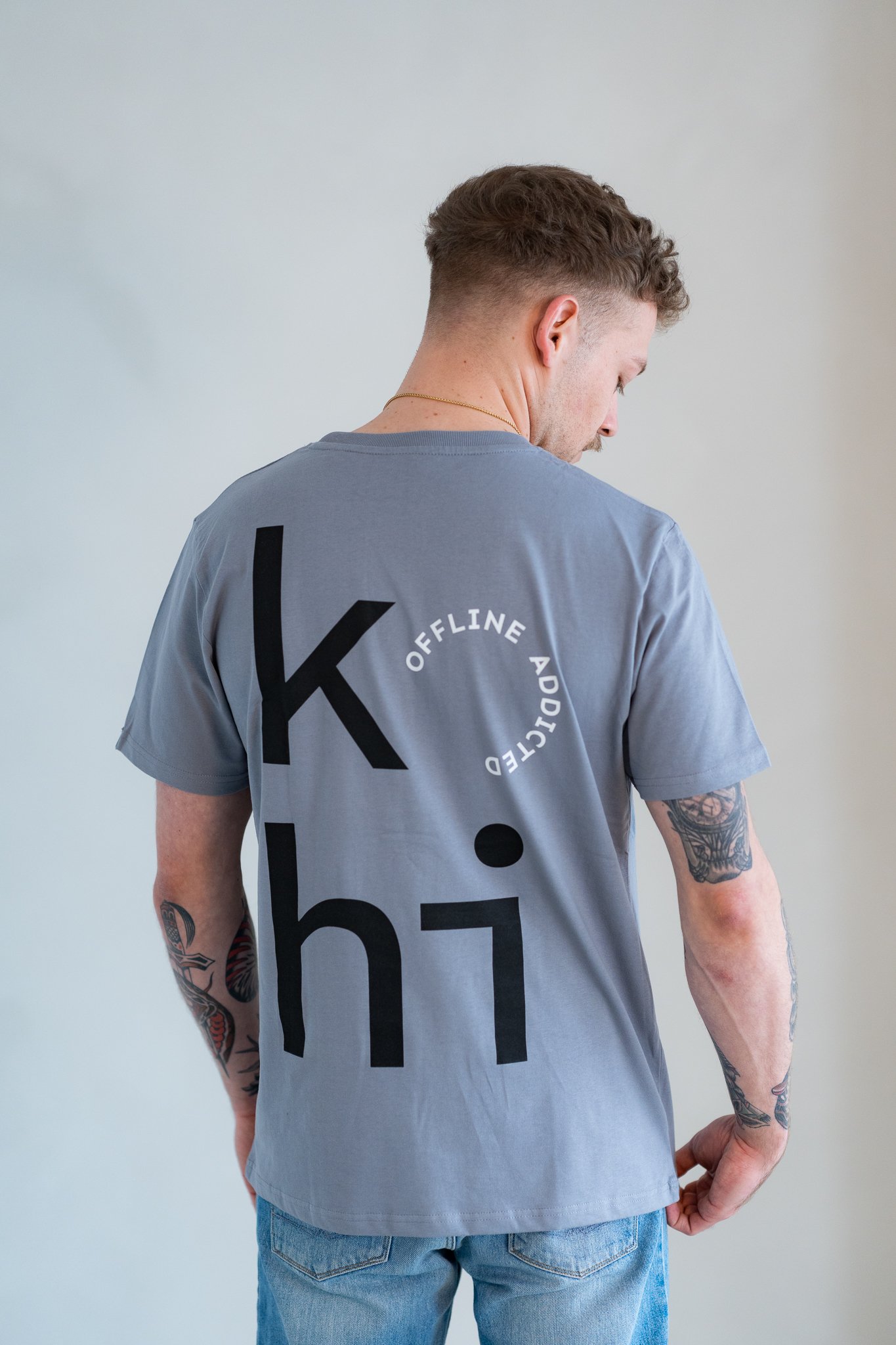 Männliches Model trägt blaugraues Tshirt mit großem kohi-Print mit offline-addicted-Stempel auf dem Rücken.