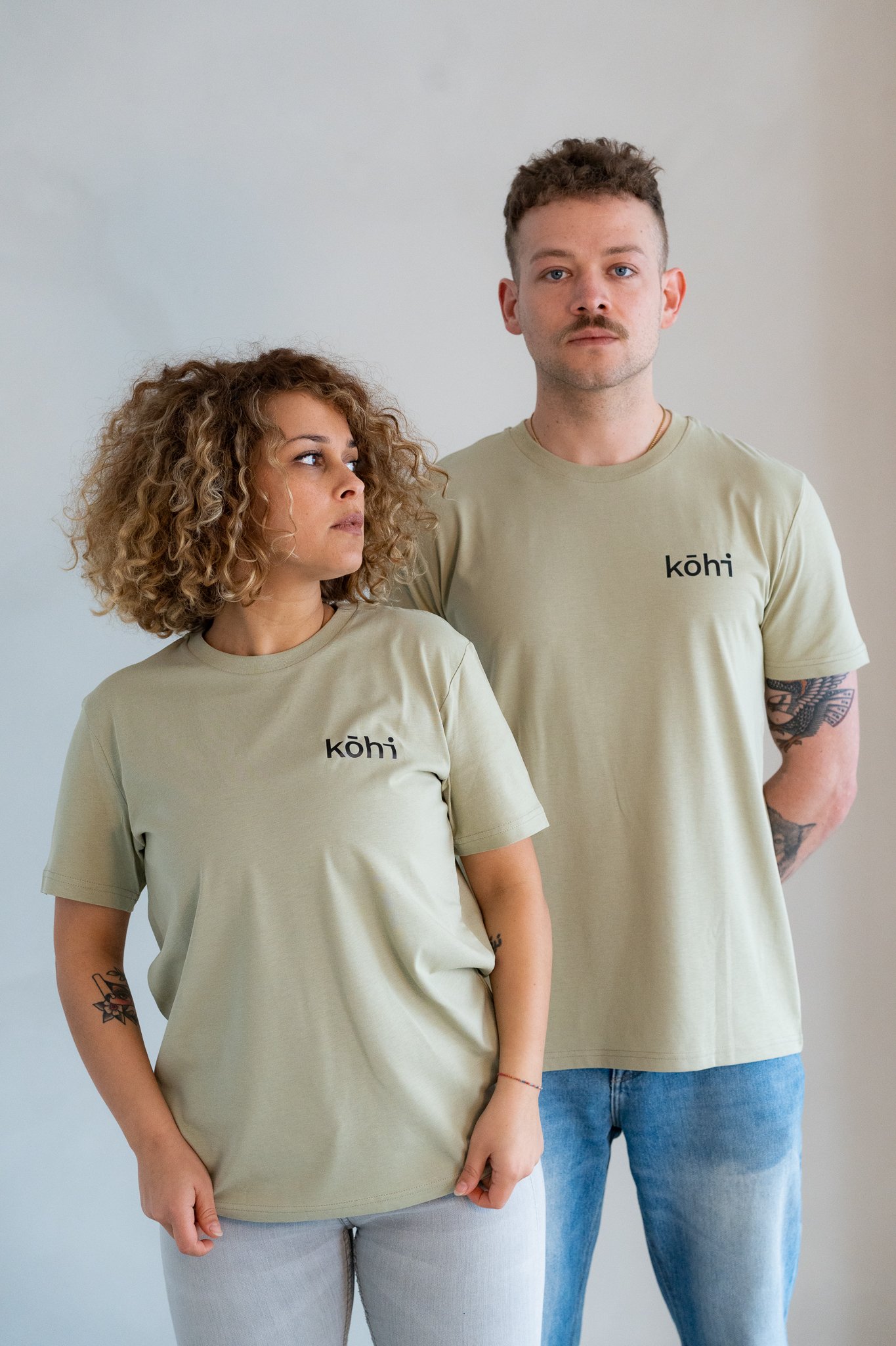 Paar trägt salbeifarbenes Tshirt mit kohi-Logo auf der Brust.
