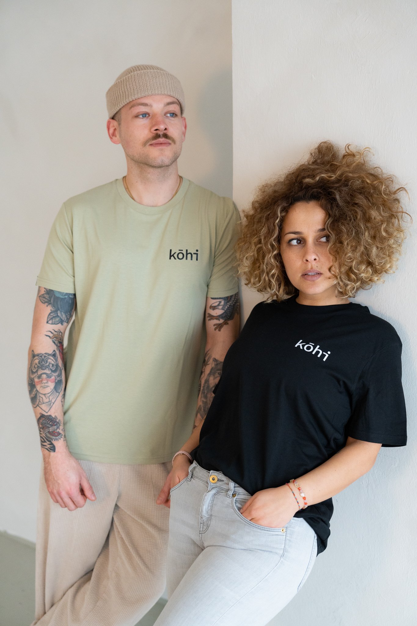 Paar trägt schwarzes und salbeifarbenes Tshirt mit kohi-Logo auf der Brust.