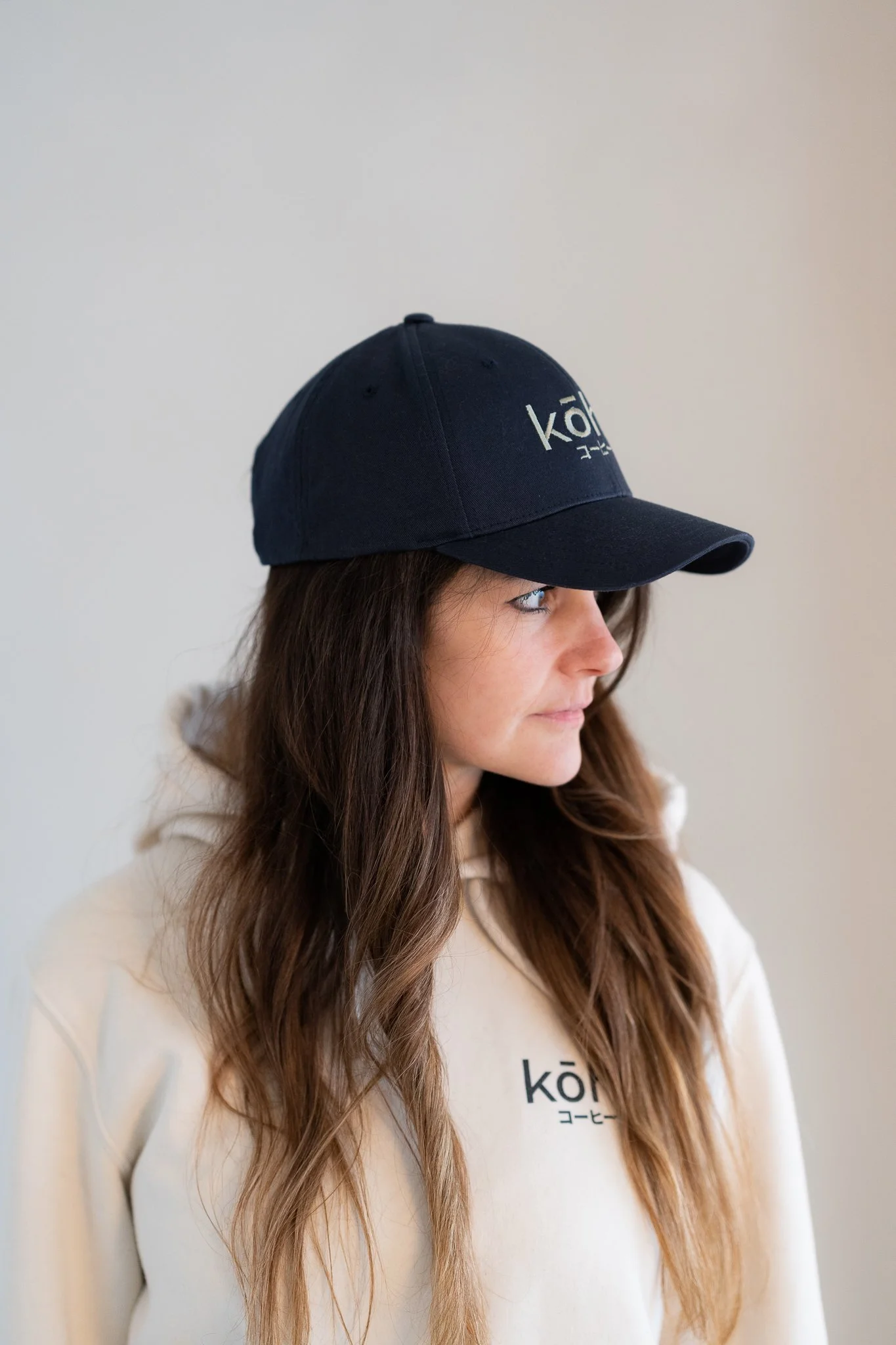 Model trägt navy-farbene Cap mit salbeifarbenen kohi Schriftzug