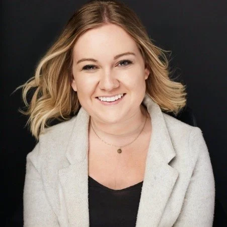 a headshot of Shailynn in a black tank, grey blazer and gold necklace