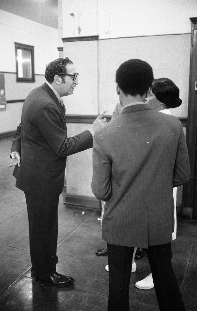 On May 12, 1971, District 10 School Superintendent Joseph Rosen scolds nurse Lois Webb for allowing the media into Penn Elementary to cover Sickle Cell Anemia testing. Observing is Ronald "Doc" Satchel. Had Nurse Webb not allowed the media in, these 