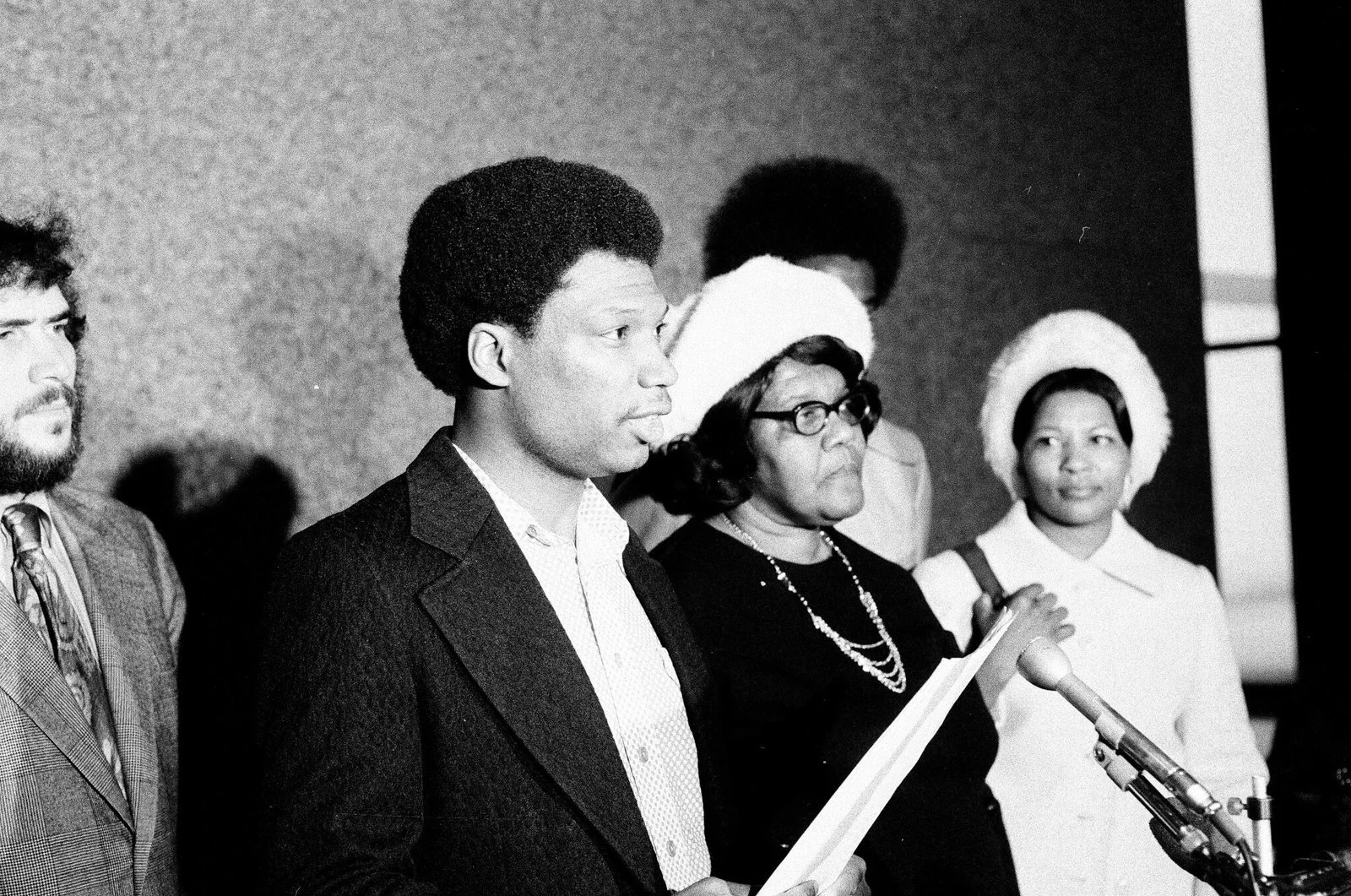 December 4, 1974. Fred Hampton's brother, Bill Hampton, stands next to Mrs. Fannie Clark, Mark Clark's mother.  Behind Bill is Jeffrey Haas of the People's Law Office. ST-19030962-0006, Chicago Sun-Times collection, Chicago History Museum
